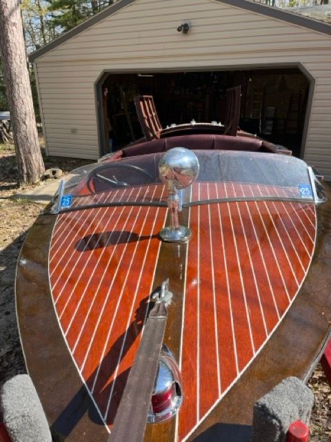 A 1938 Chris-Craft Custom Deluxe Runabout in a garage.