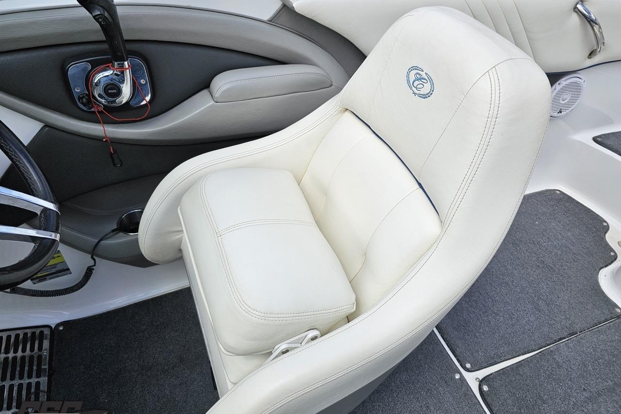 2010 Cobalt 232 WSS boat interior with white leather captain's chair and steering wheel.