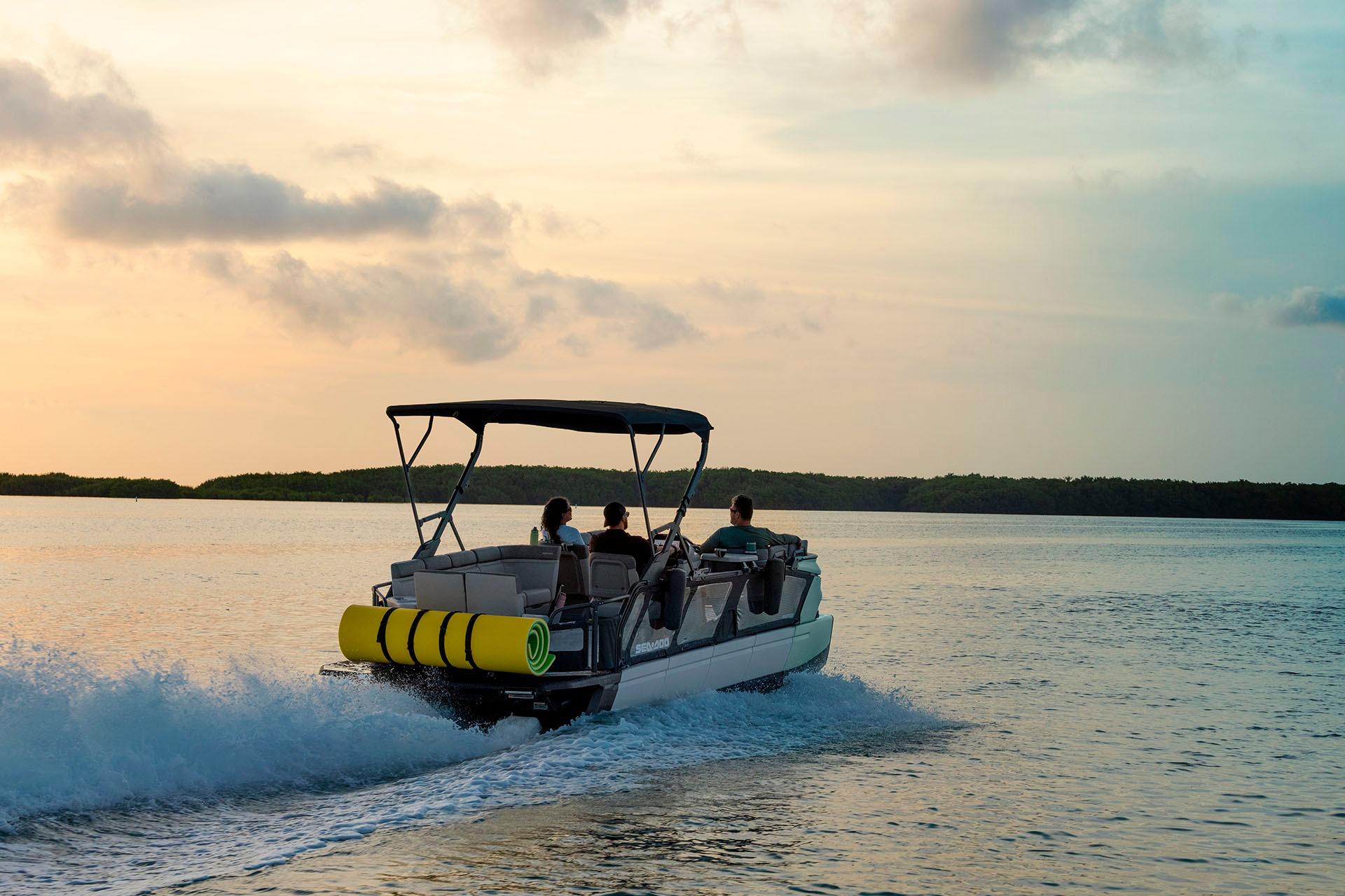 2026 Sea-Doo Switch Cruise 21 pontoon boat cruising at sunset on calm waters.
