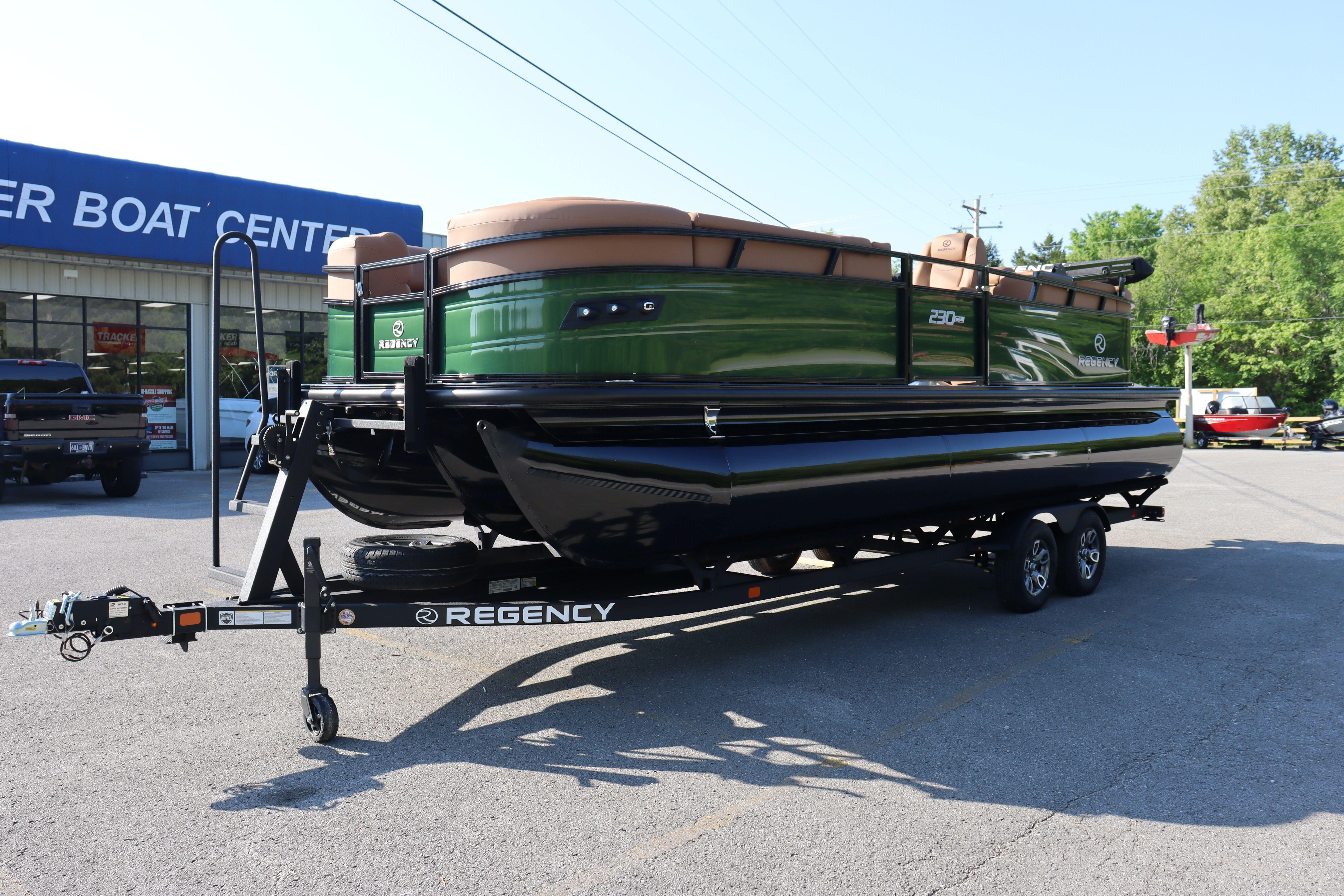 2026 Regency 230 DL pontoon boat on trailer at dealership parking lot.