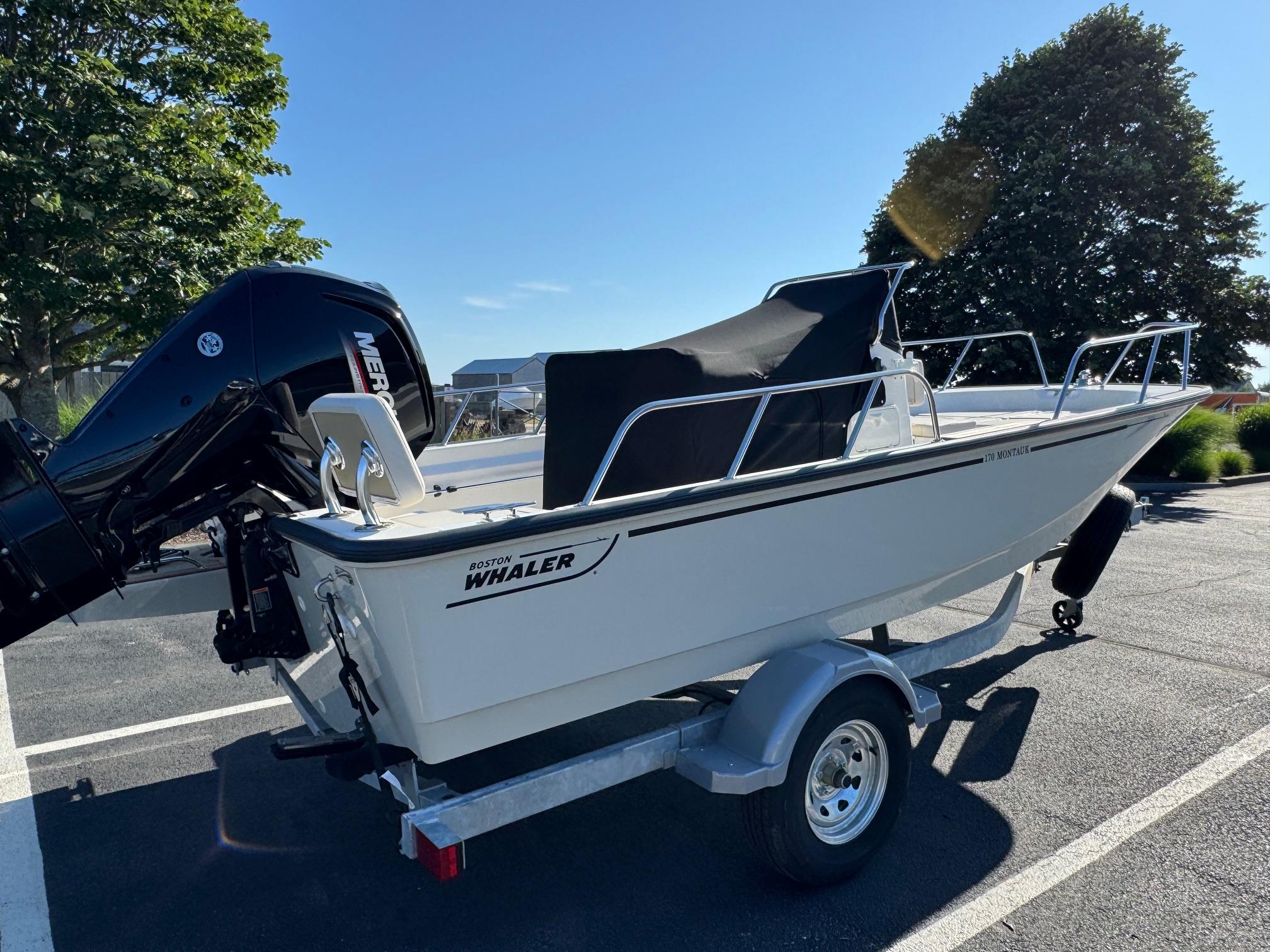 2025 Boston Whaler 170 Montauk boat on trailer, parked outdoors.