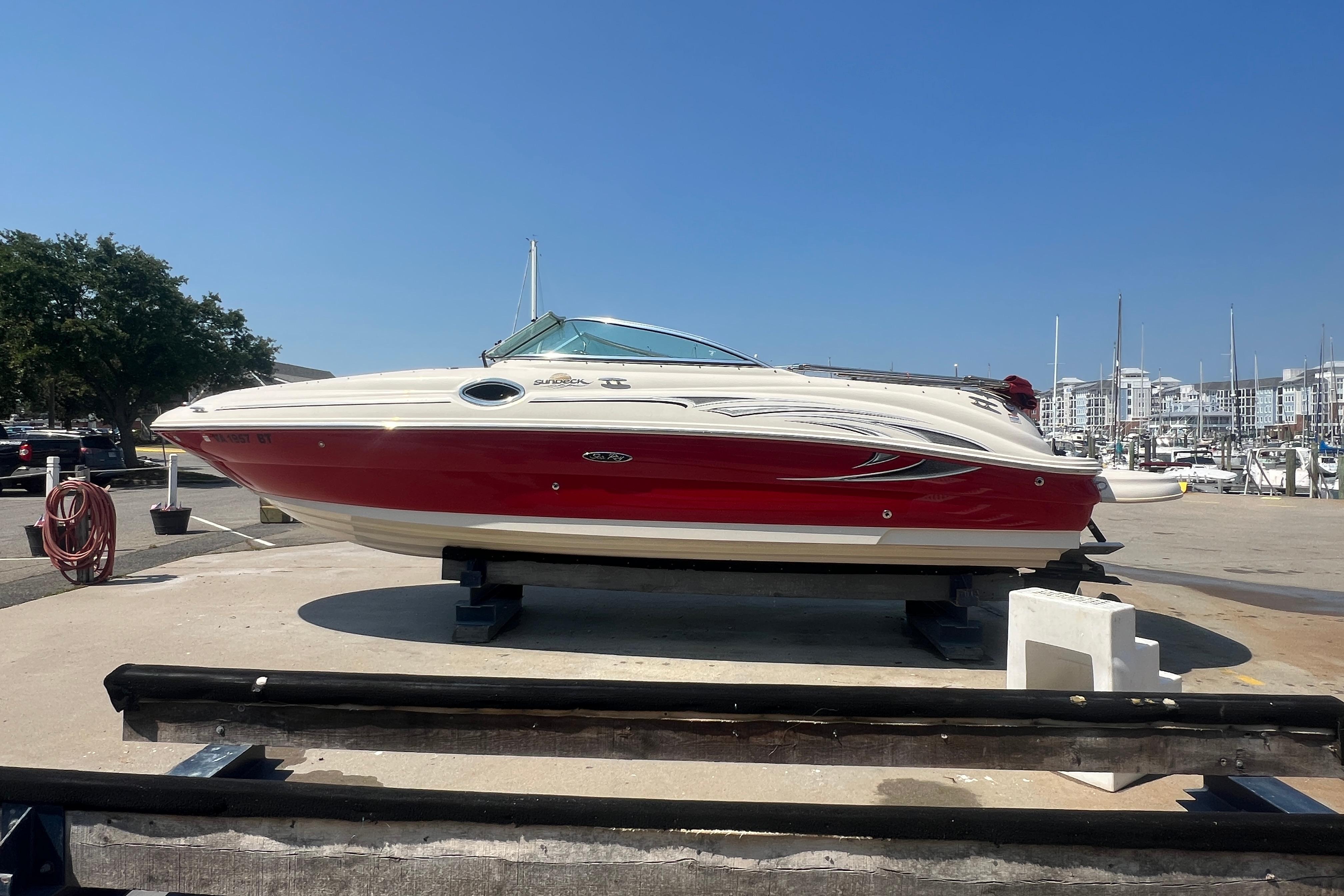 2005 Sea Ray 240 Sundeck boat on display at a marina under clear blue skies.