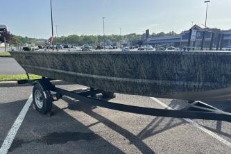 2026 Tracker Grizzly 1648 Utility boat on trailer in parking lot.