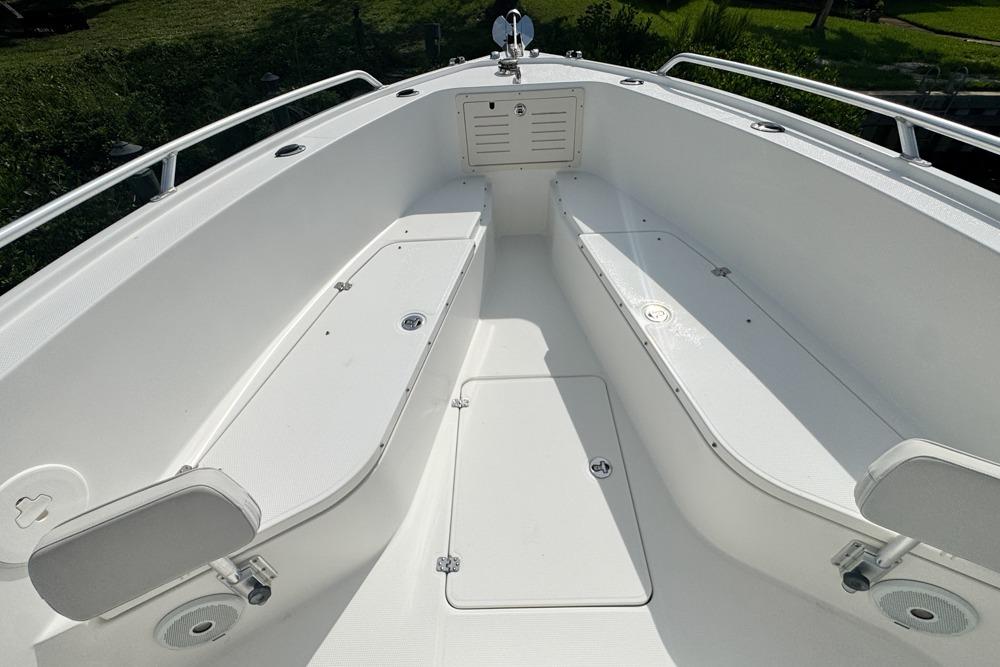 2018 Mako 284 Center Console boat interior with white seating and storage compartments.
