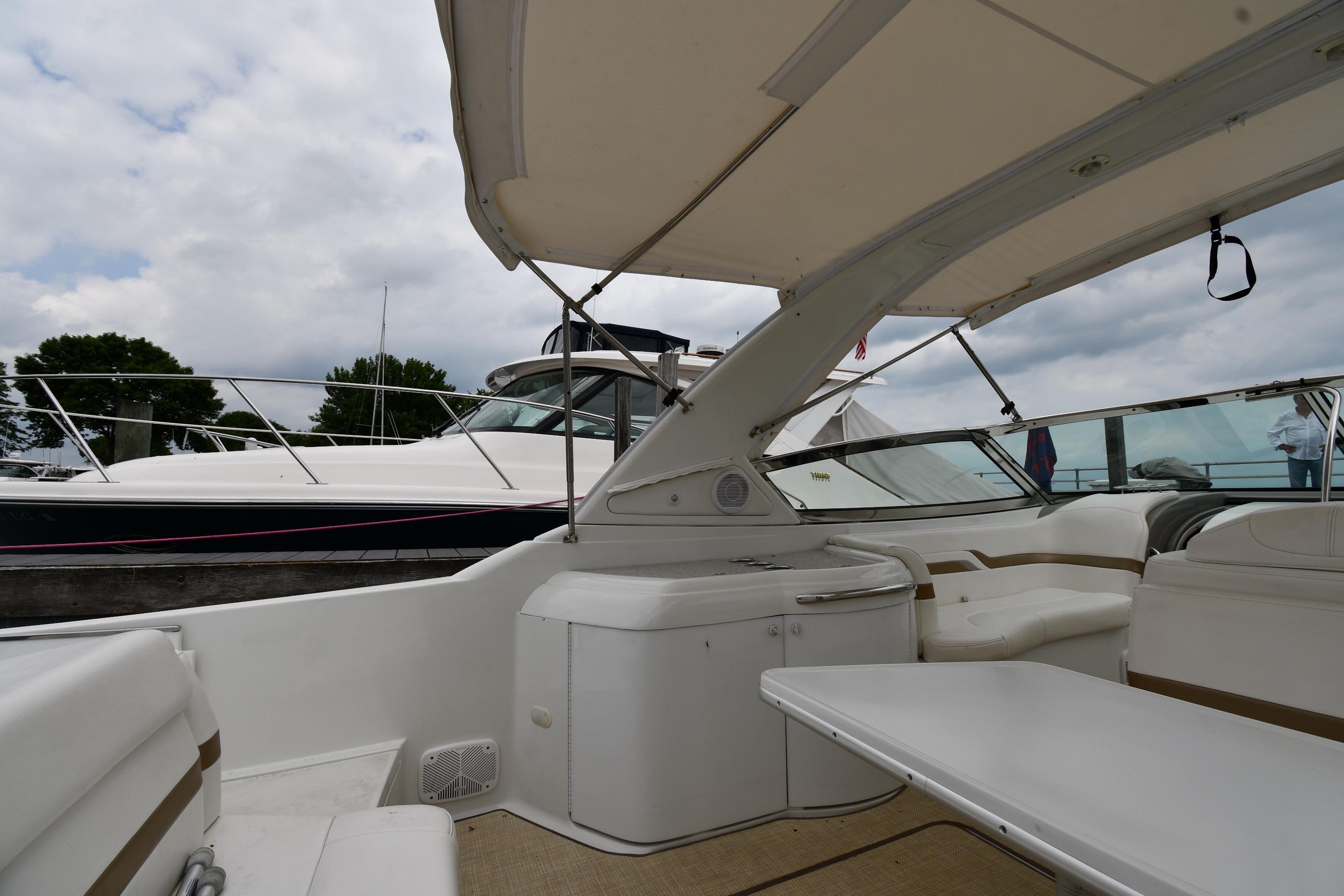 2004 Formula 330 Sun Sport boat interior with seating and table under canopy.