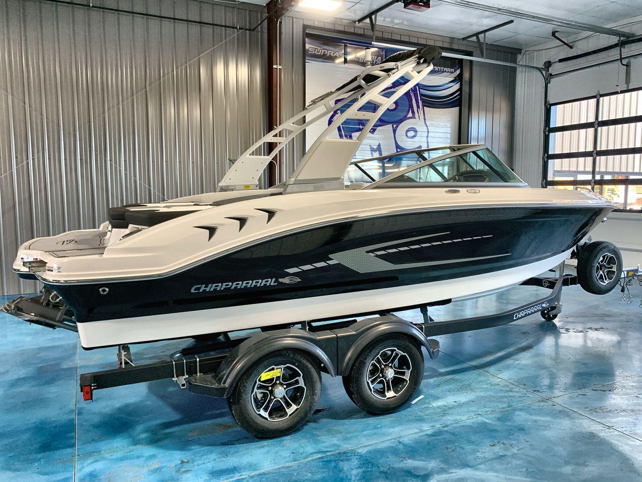 2025 Chaparral 21 SSi boat on trailer in showroom, side view.