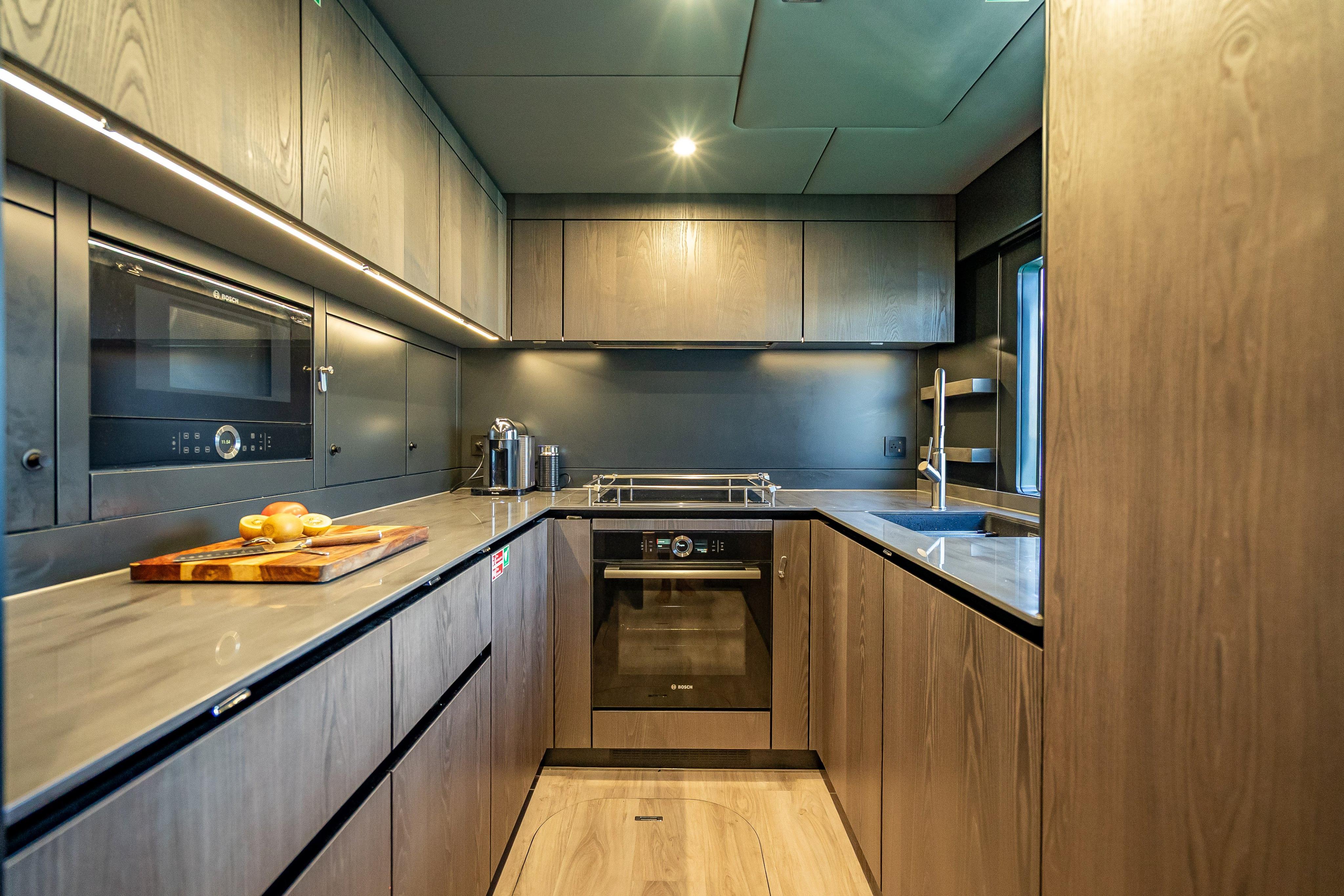 Modern kitchen interior on 2026 Sunreef 60 Power yacht, featuring sleek cabinetry and appliances.