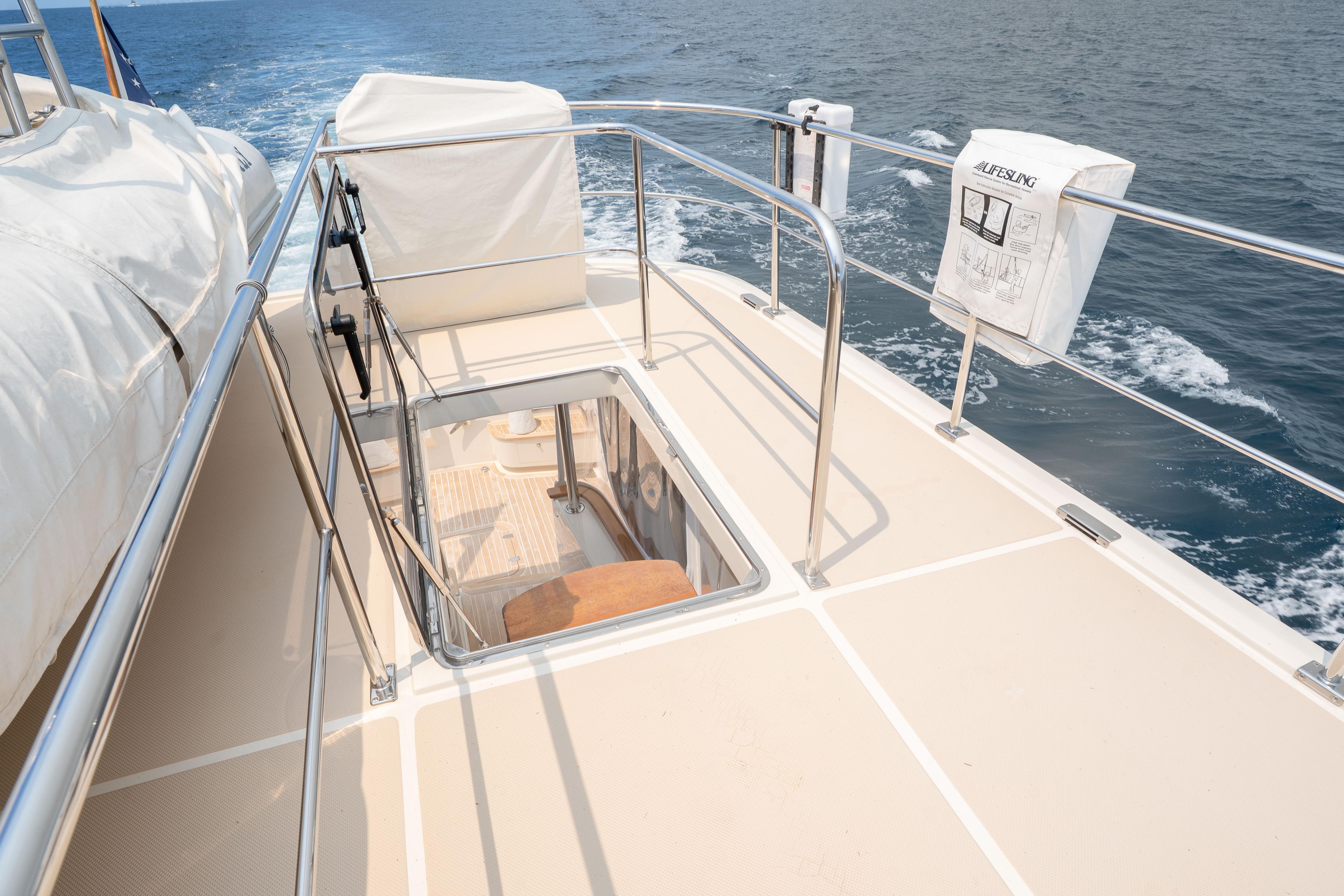 Deck view of 2006 Fleming 75 yacht with open hatch and ocean backdrop.