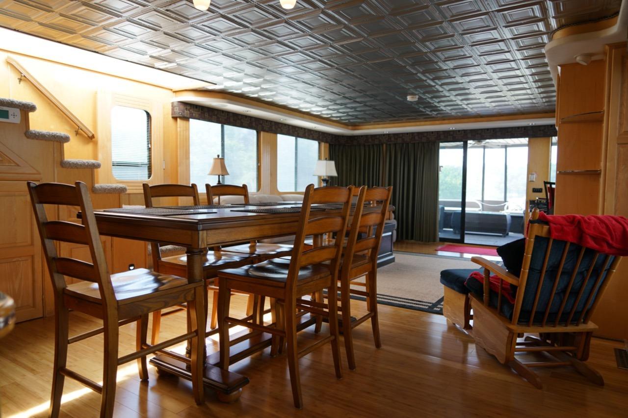 Interior of 2000 Stardust Cruisers houseboat with dining area and cozy seating.