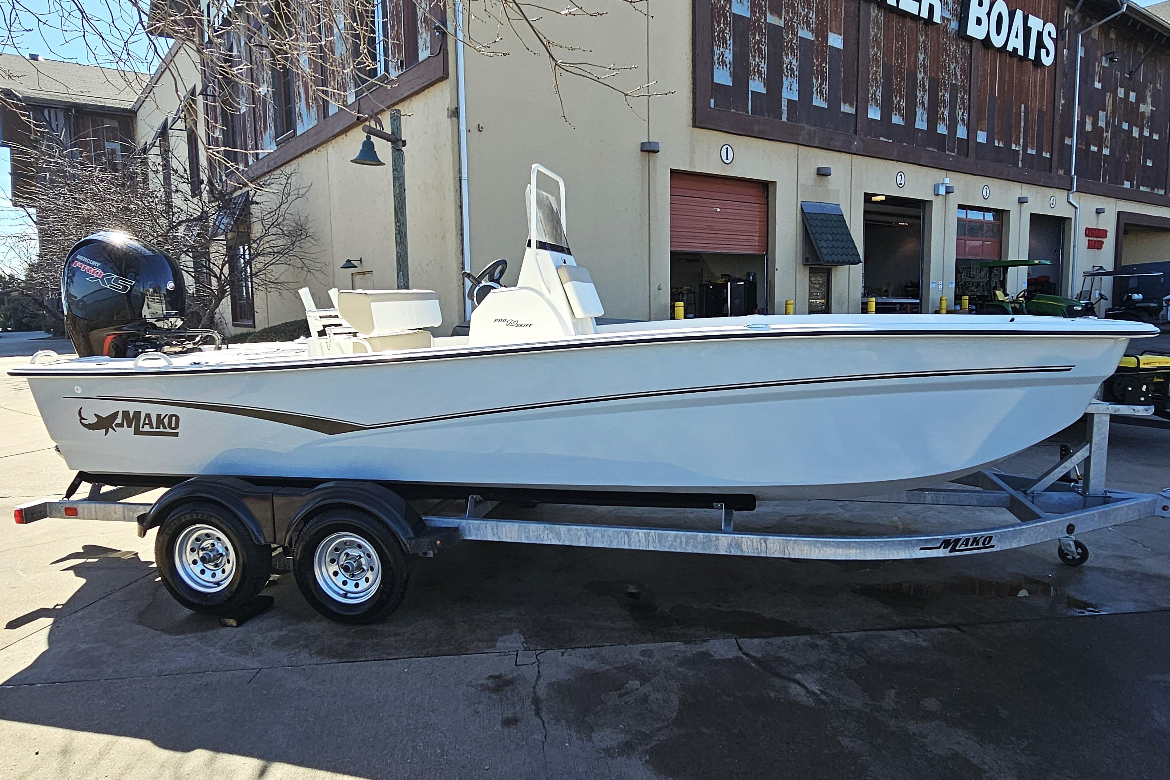 2026 Mako Pro Skiff 19 CC boat on trailer outside a building.