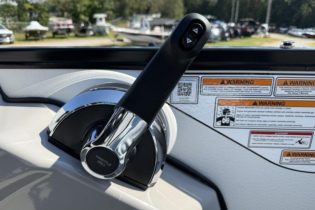 Throttle control of 2026 Premier 220 Sunscape RF boat with warning labels in background.