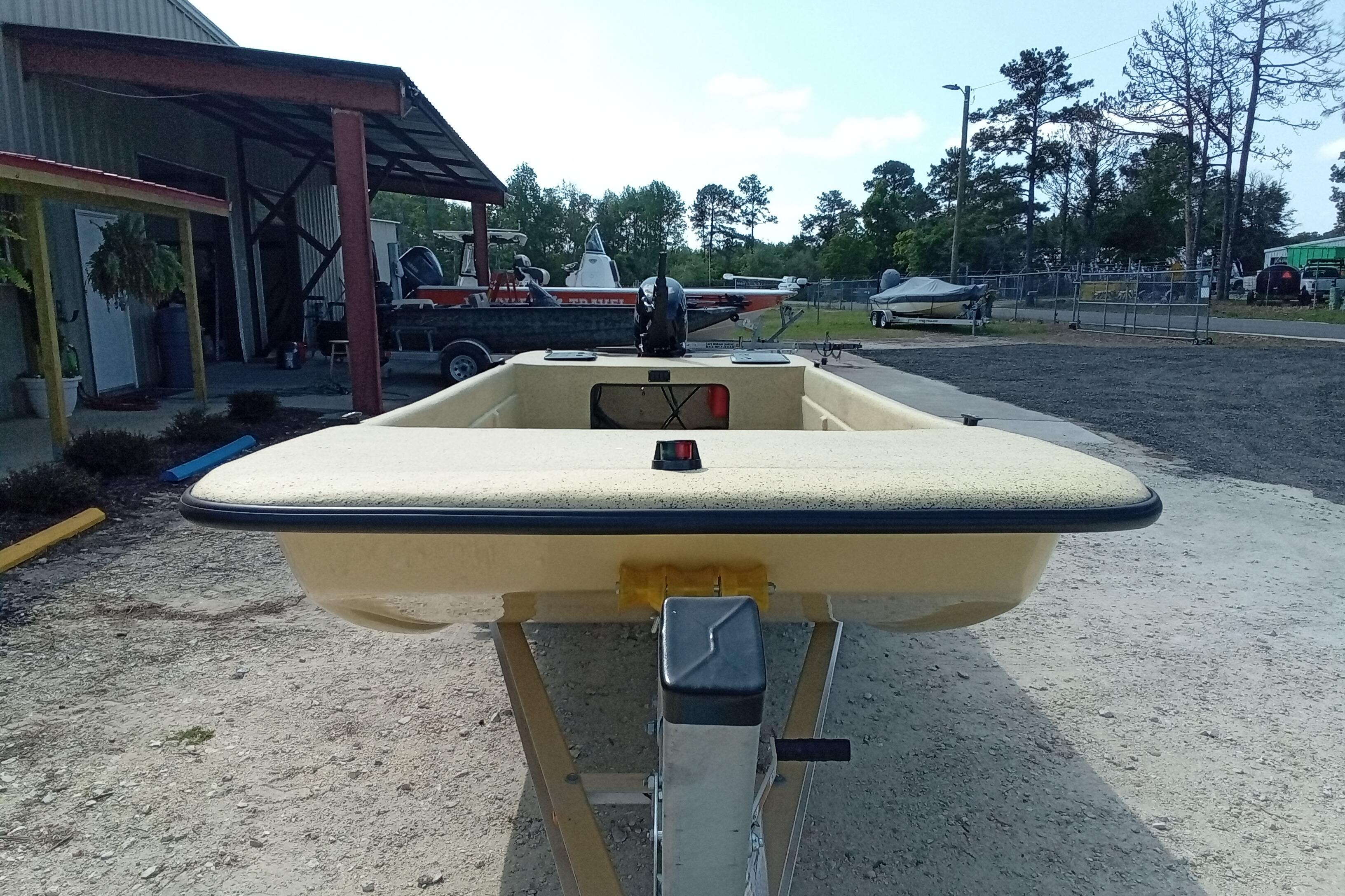 Fibercraft F17 boat, 2025 model, parked outdoors near a metal building.