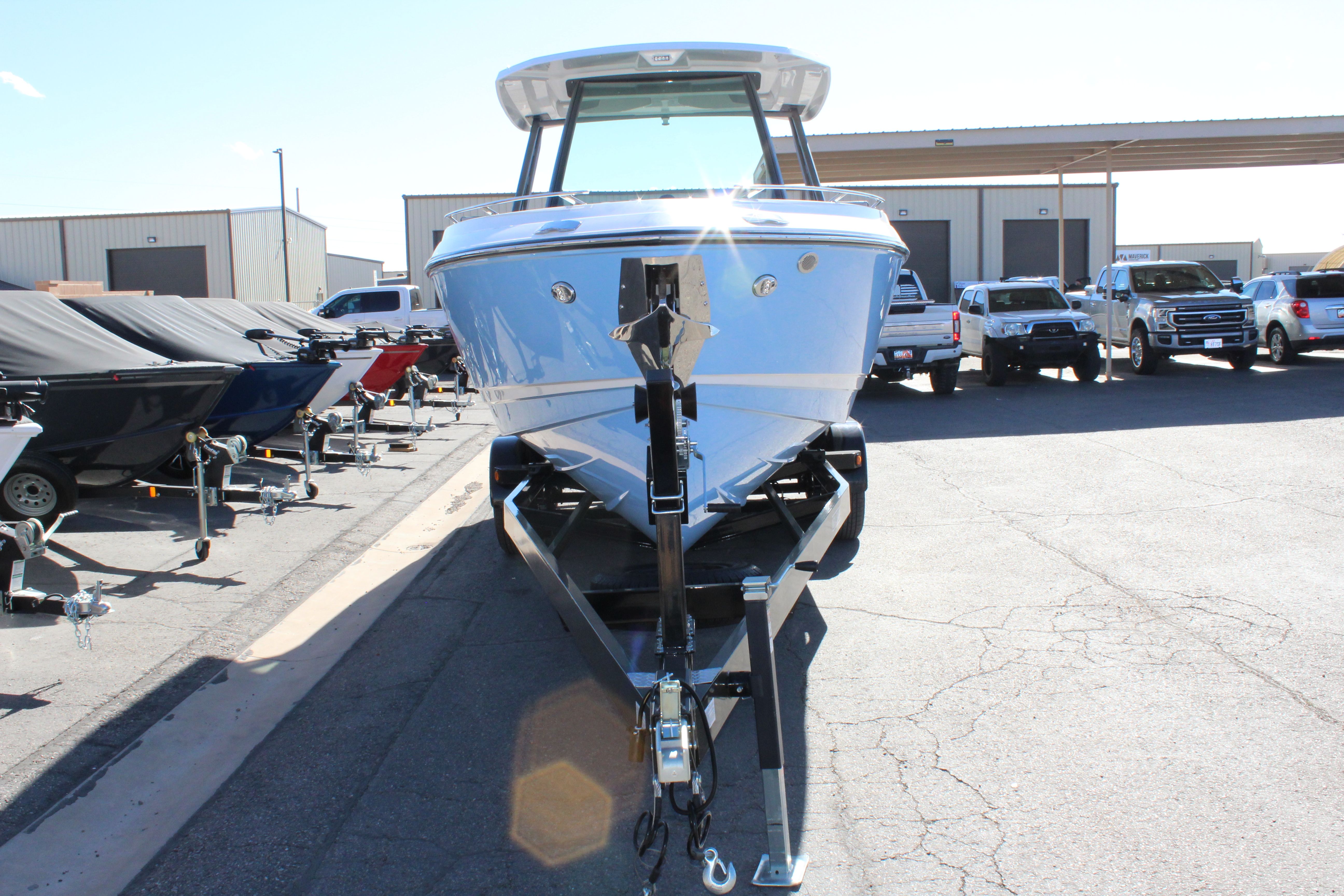 2025 Monterey Elite 27 OB boat on trailer outdoors.