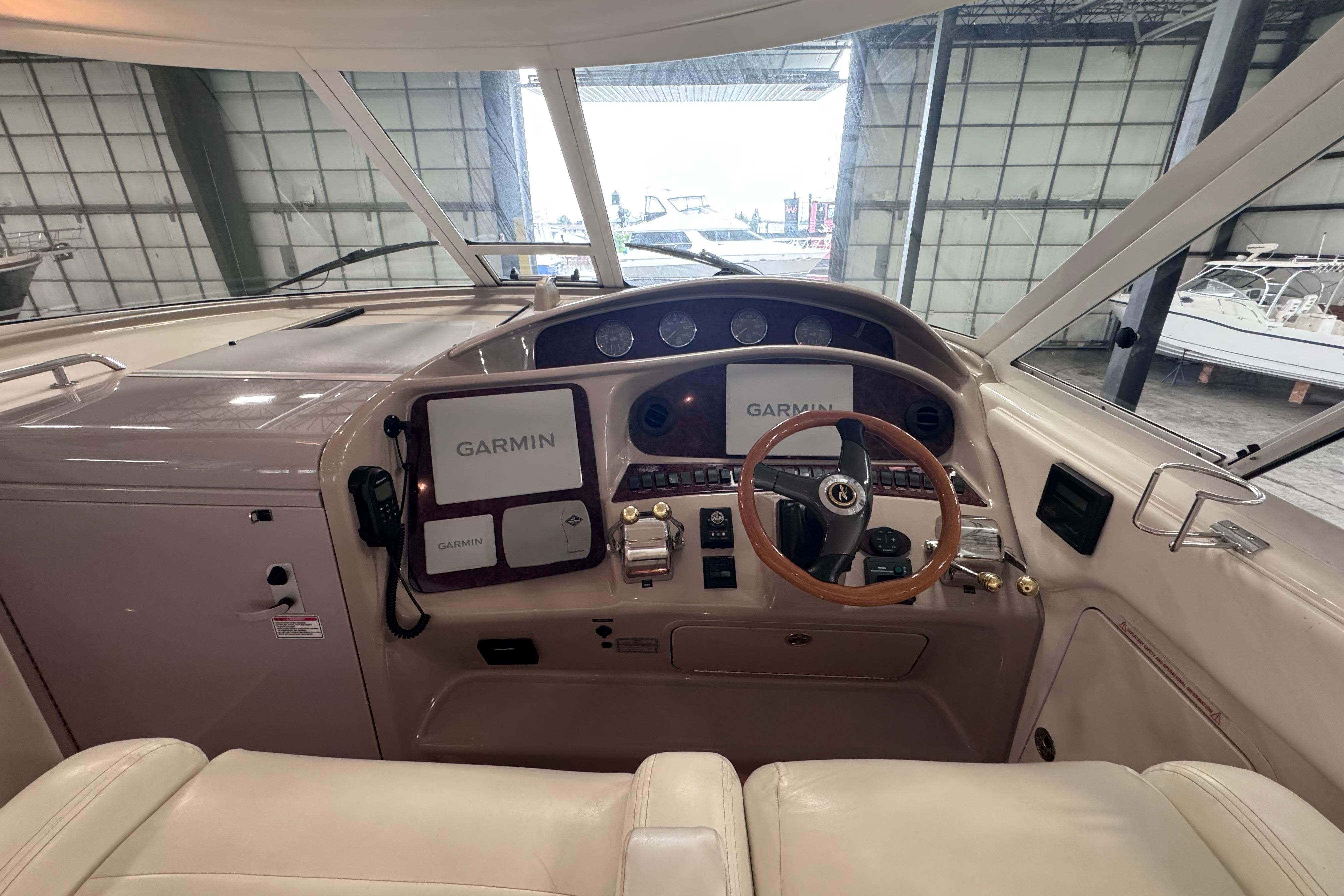 2004 Sea Ray 390 Motor Yacht helm with Garmin navigation system in a marina setting.