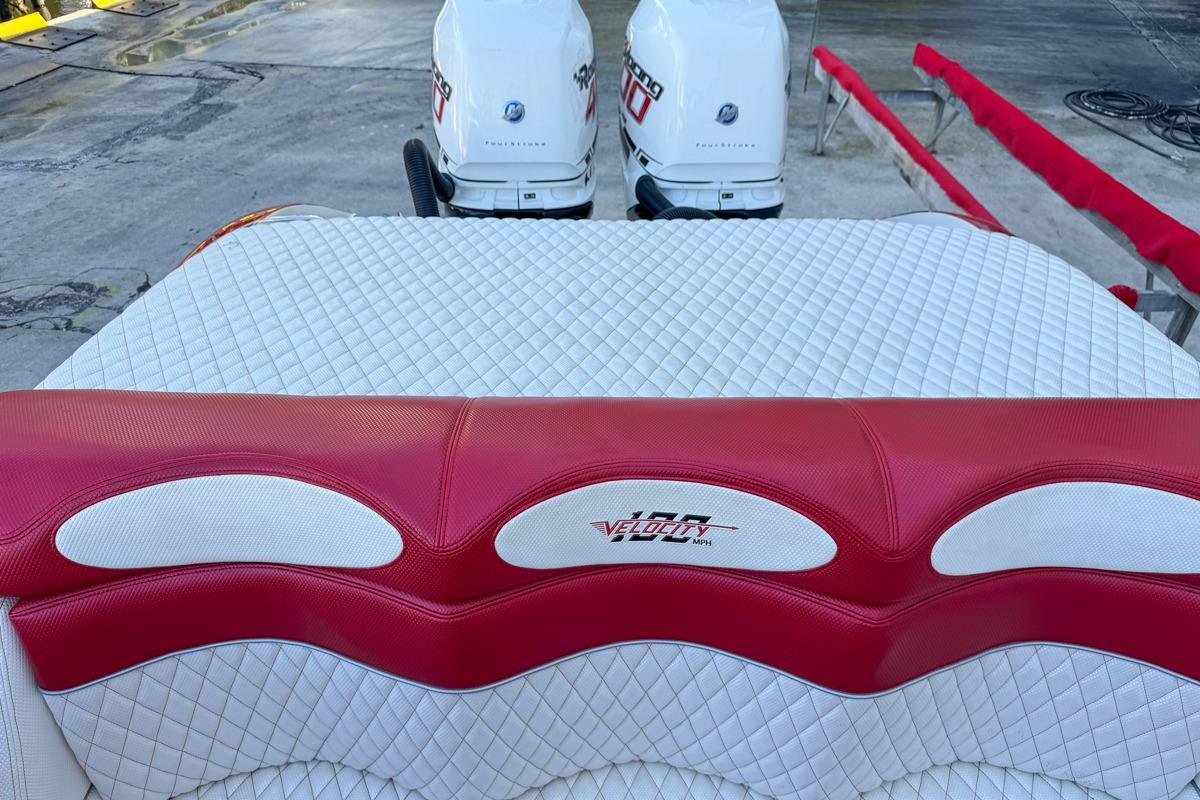 2022 Velocity 290sc boat with red and white quilted seating and dual outboard motors.