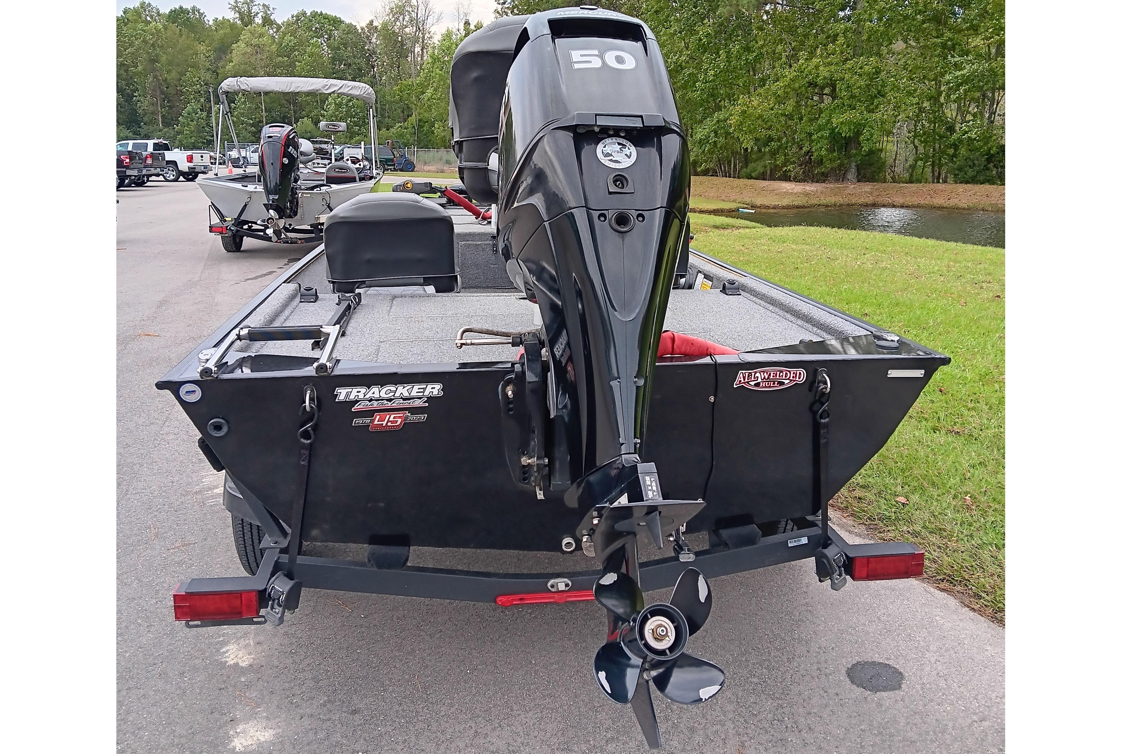 2023 Tracker Bass Tracker Classic XL boat with 50 HP motor, parked near a pond.