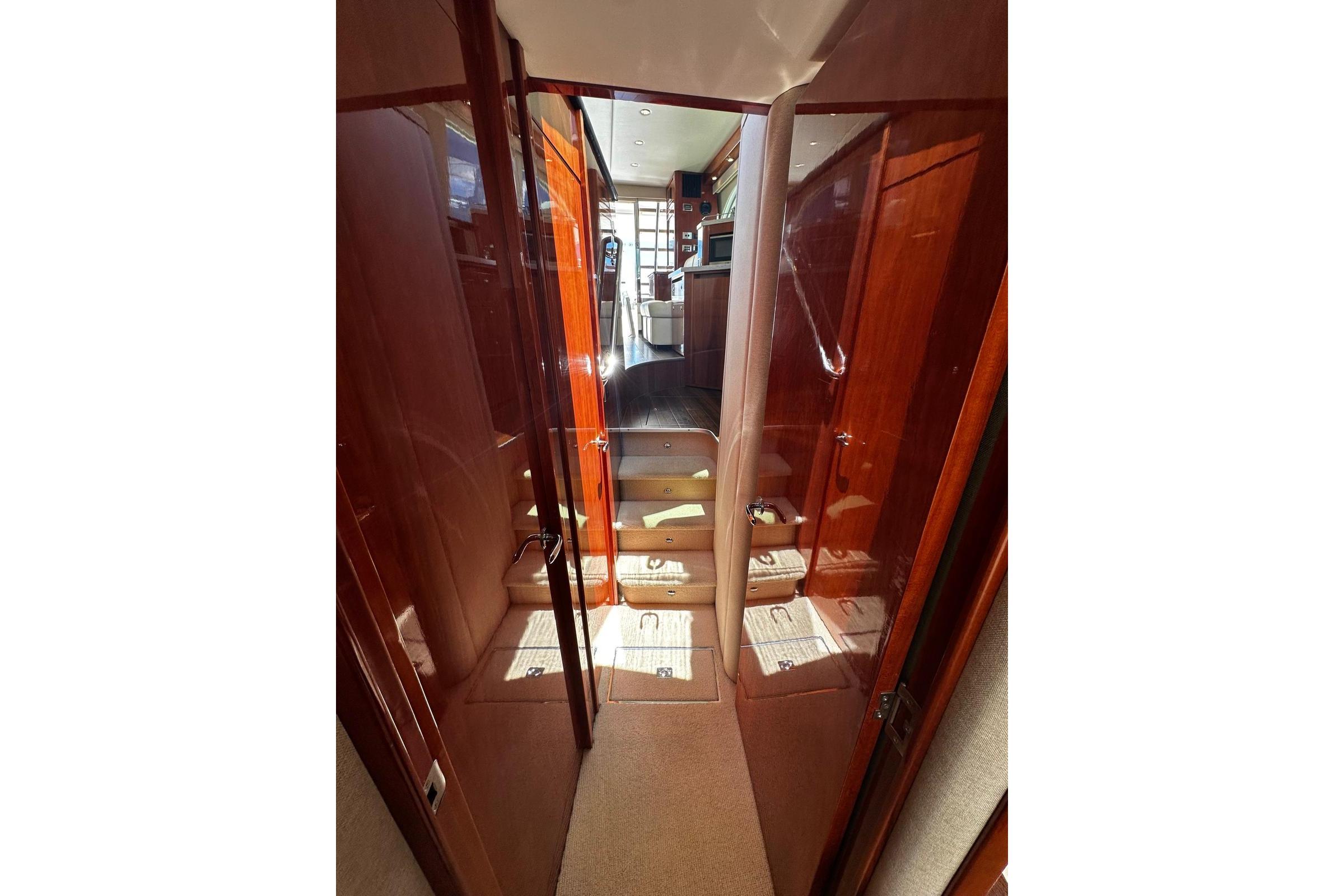 Interior hallway of 2012 Riviera 43 Flybridge yacht with polished wood finish.
