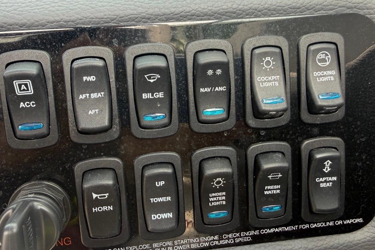 Control panel of a 2024 Regal LX2 boat with various switches.