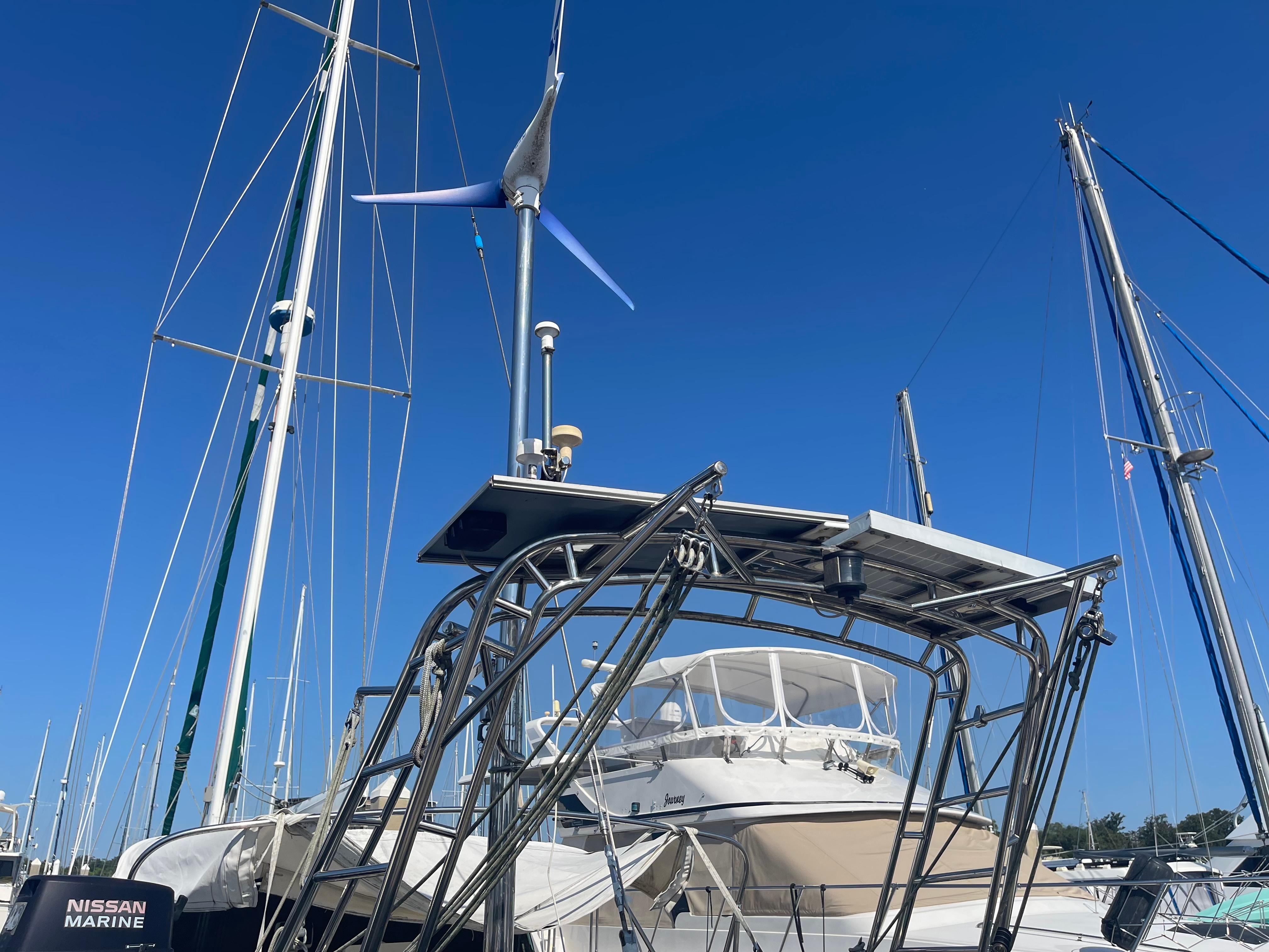 Sailboat Passport 47 AC Plan B 1995 docked with wind turbine and solar panels.