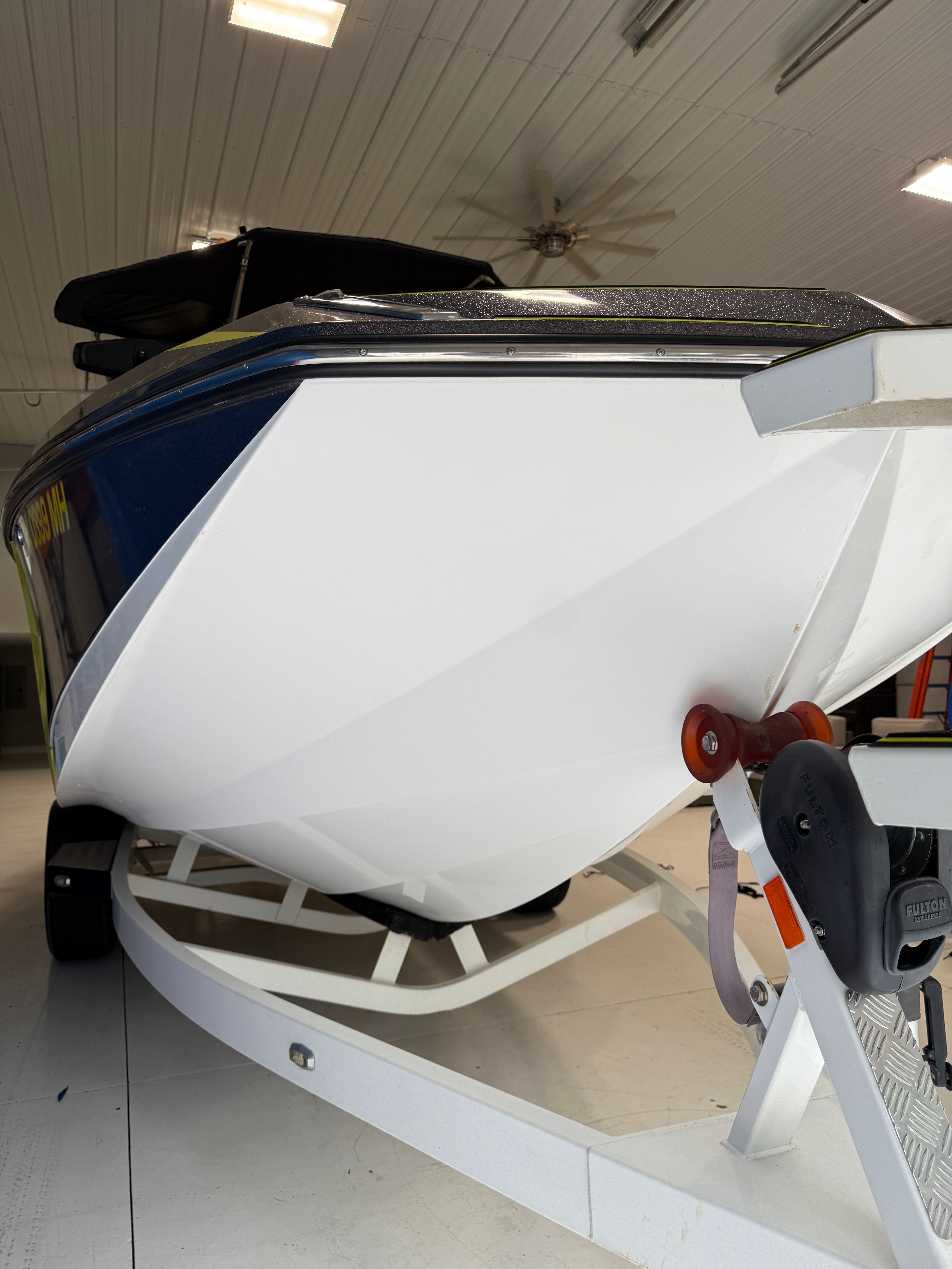 A 2016 Nautique Super Air Nautique G23 on a trailer inside a building.