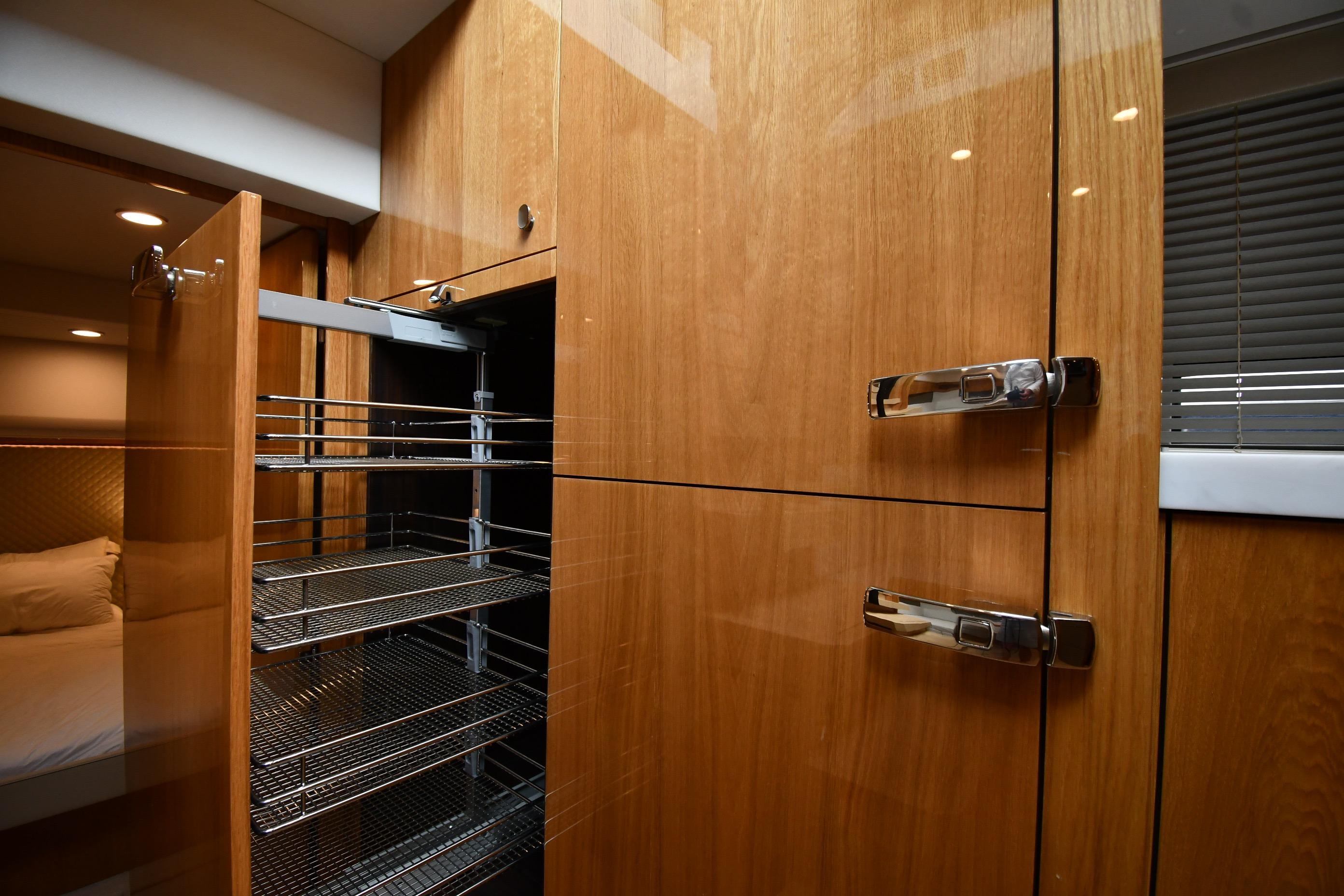 Interior of 2024 Fairline G50 Targa yacht with wooden cabinetry and pull-out storage.