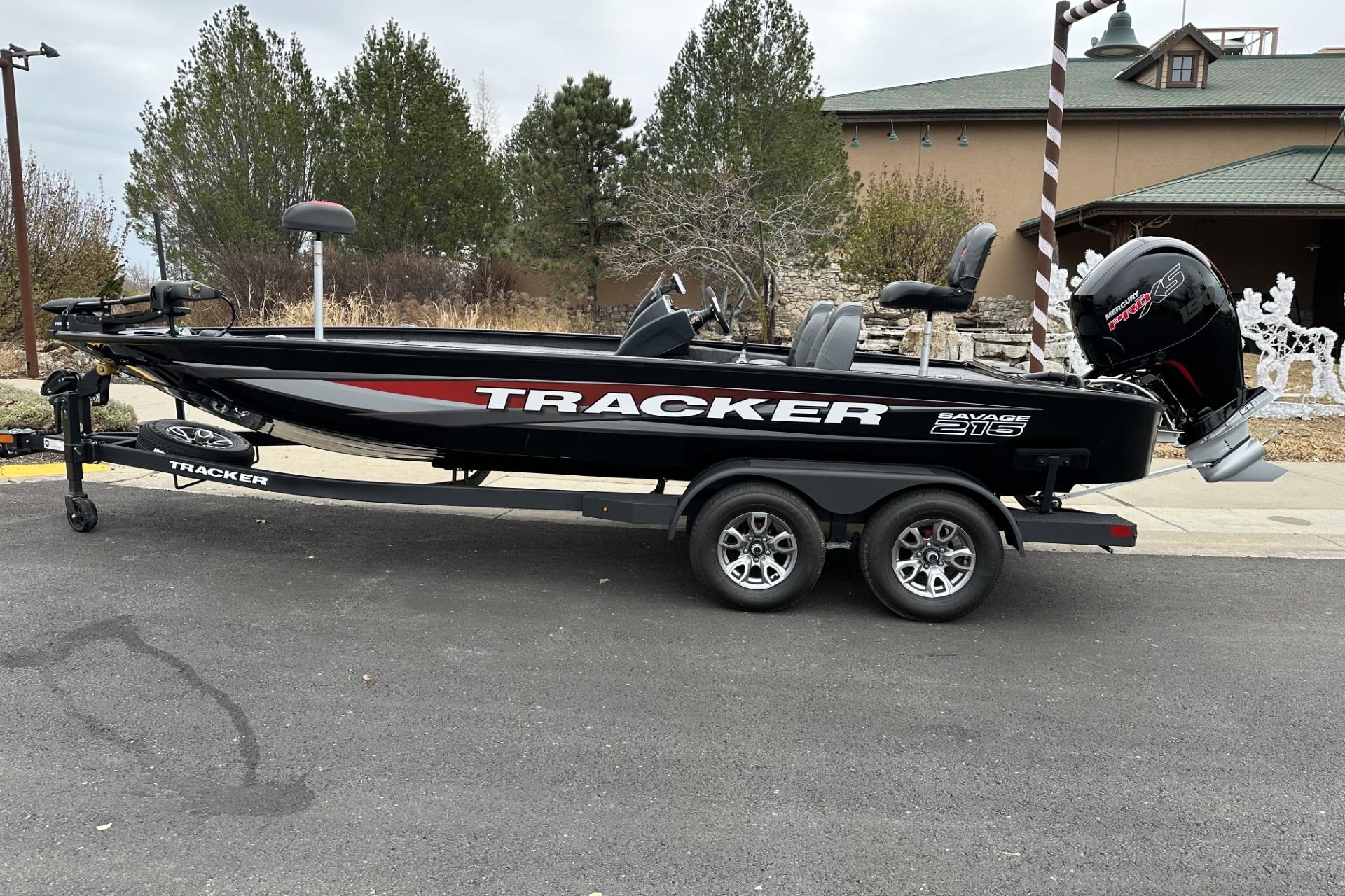 2025 Tracker Savage 215 boat on trailer, parked outdoors near a building.