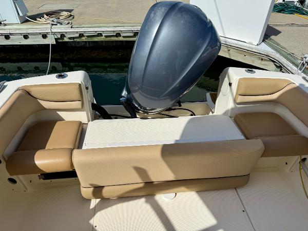 2016 Scout 245 Dorado boat with beige seating and outboard motor at dock.