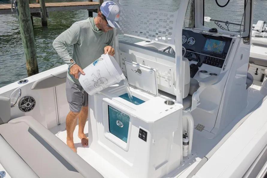 Man pouring water into a compartment on a 2025 Hurricane Center Console 24 OB boat.