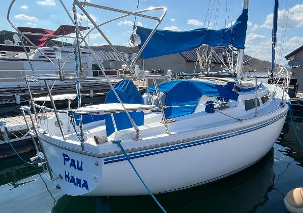 1980 Catalina 30 sailboat docked, featuring blue covers and white hull.