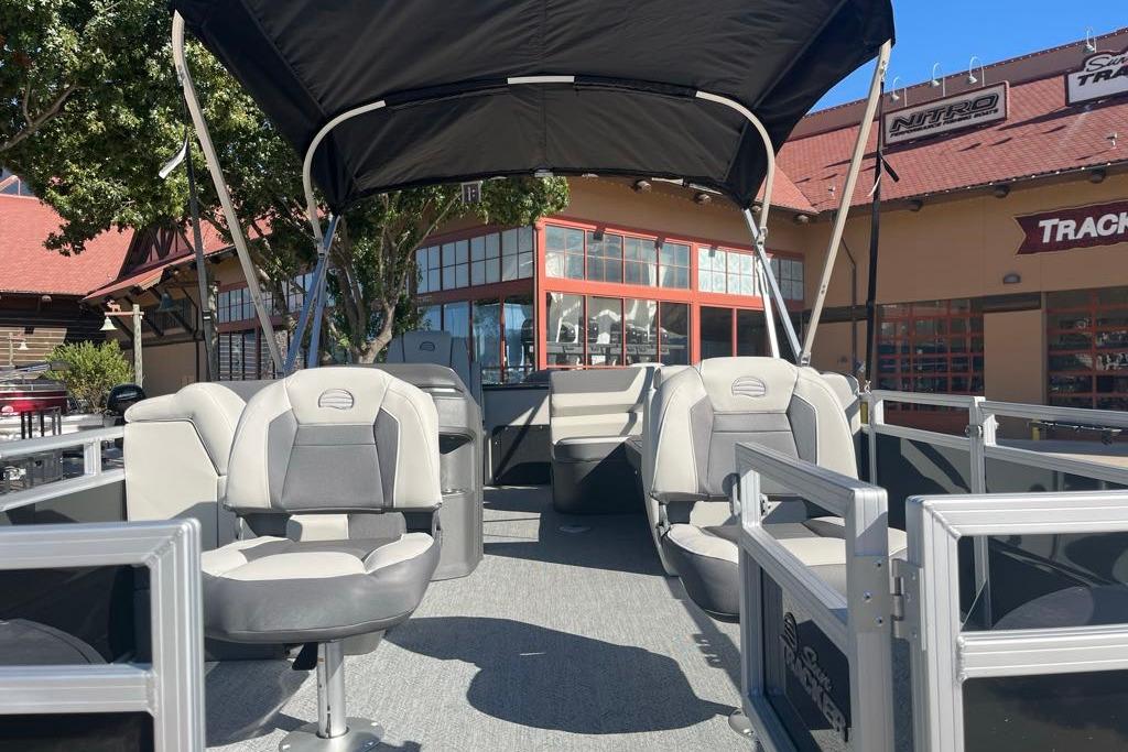 2026 Sun Tracker Fishin' Barge 22 DLX pontoon boat with seating and canopy.