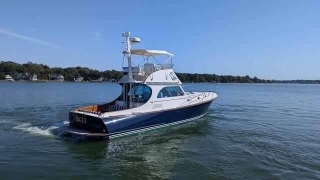 2007 Hinckley Talaria 44 Flybridge yacht cruising on a calm lake.