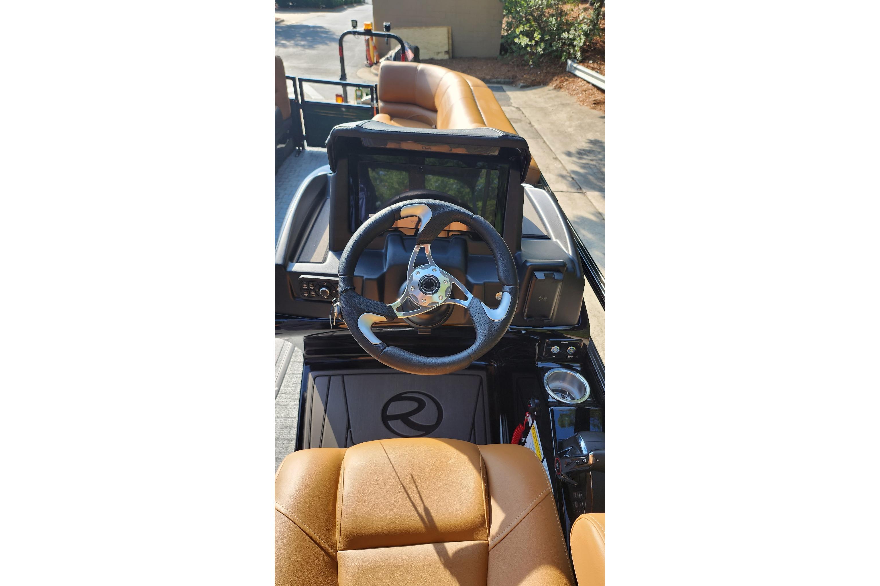 2026 Regency 230 DL boat interior with steering wheel and tan seating.