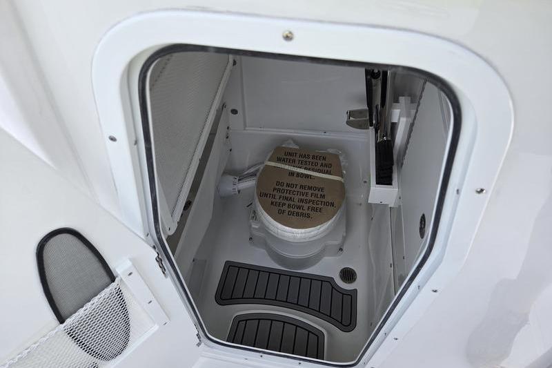 Storage compartment of 2027 Sea Hunt Ultra 275 SE boat, featuring a secured container.