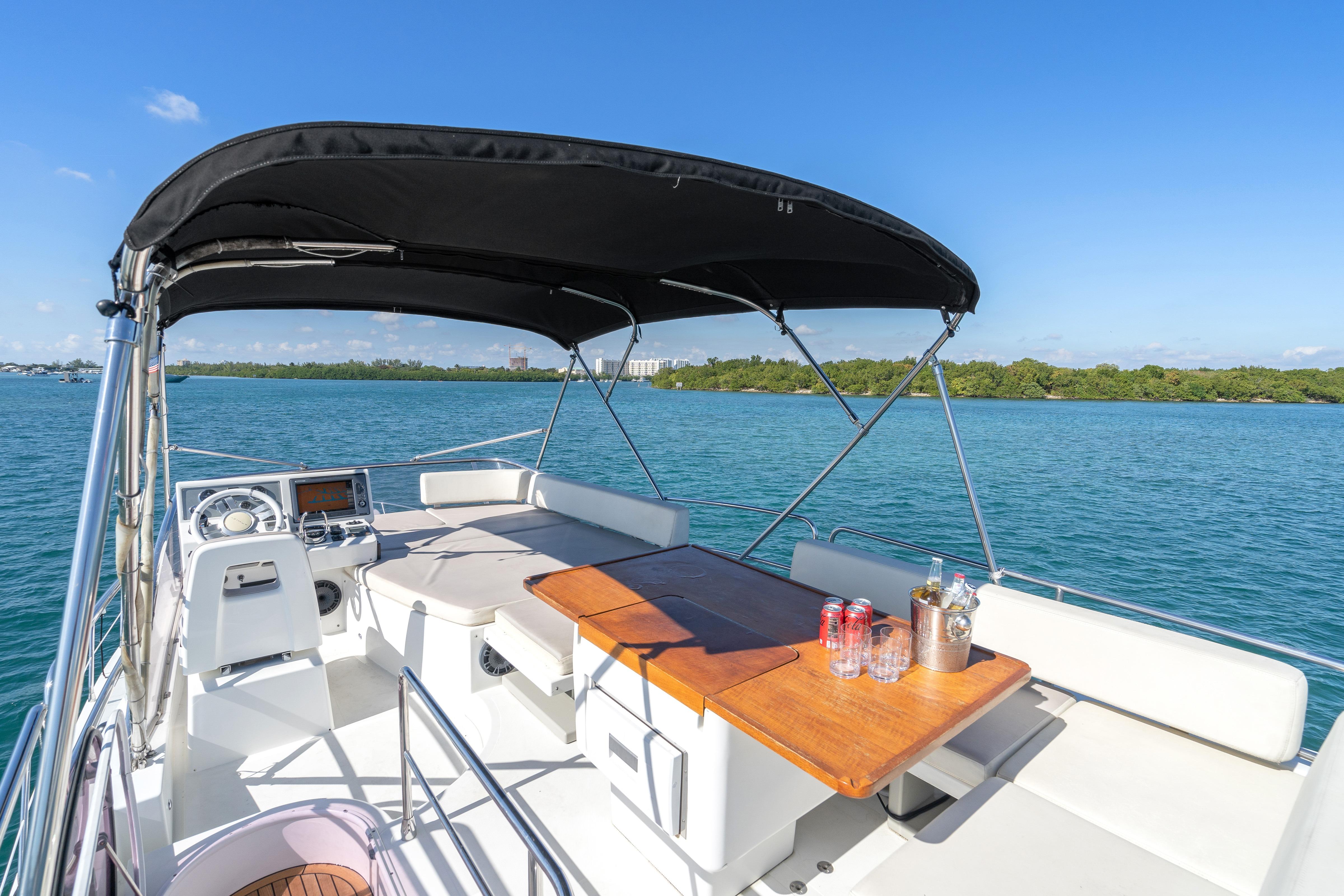 2013 Azimut 45 Flybridge yacht with shaded seating area and ocean view.
