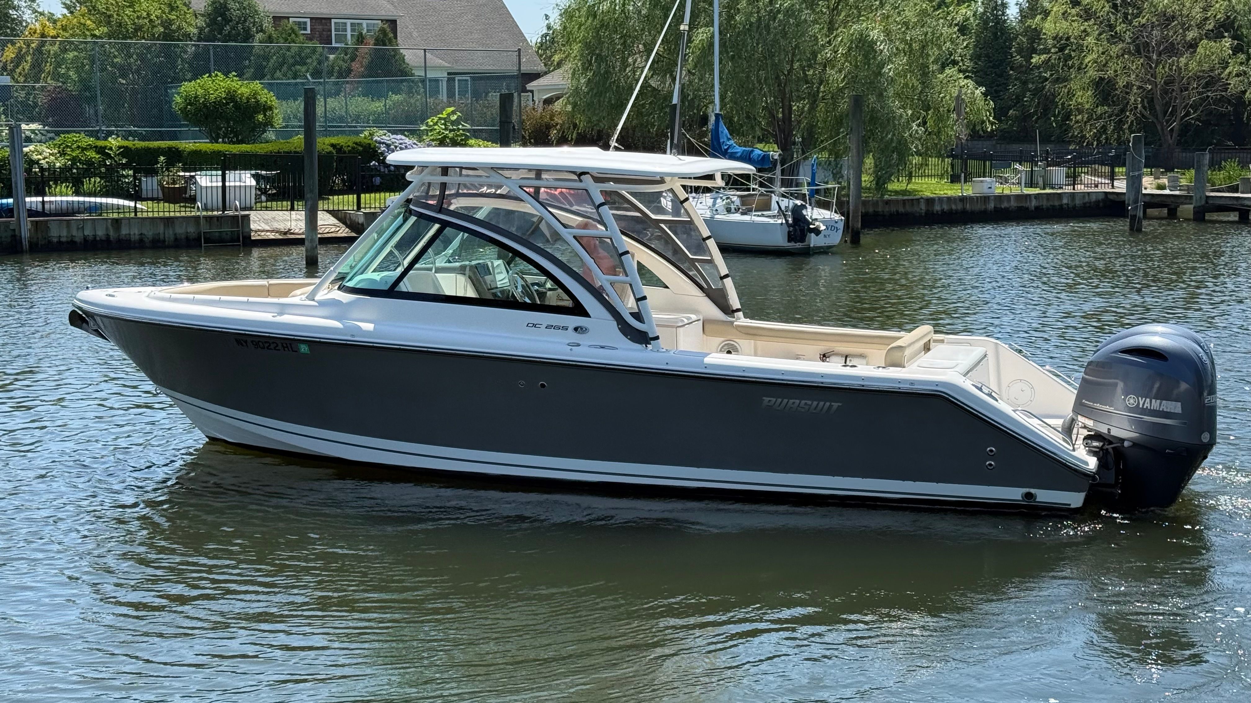 A 2016 Pursuit DC 265 Dual Console boat on calm water.