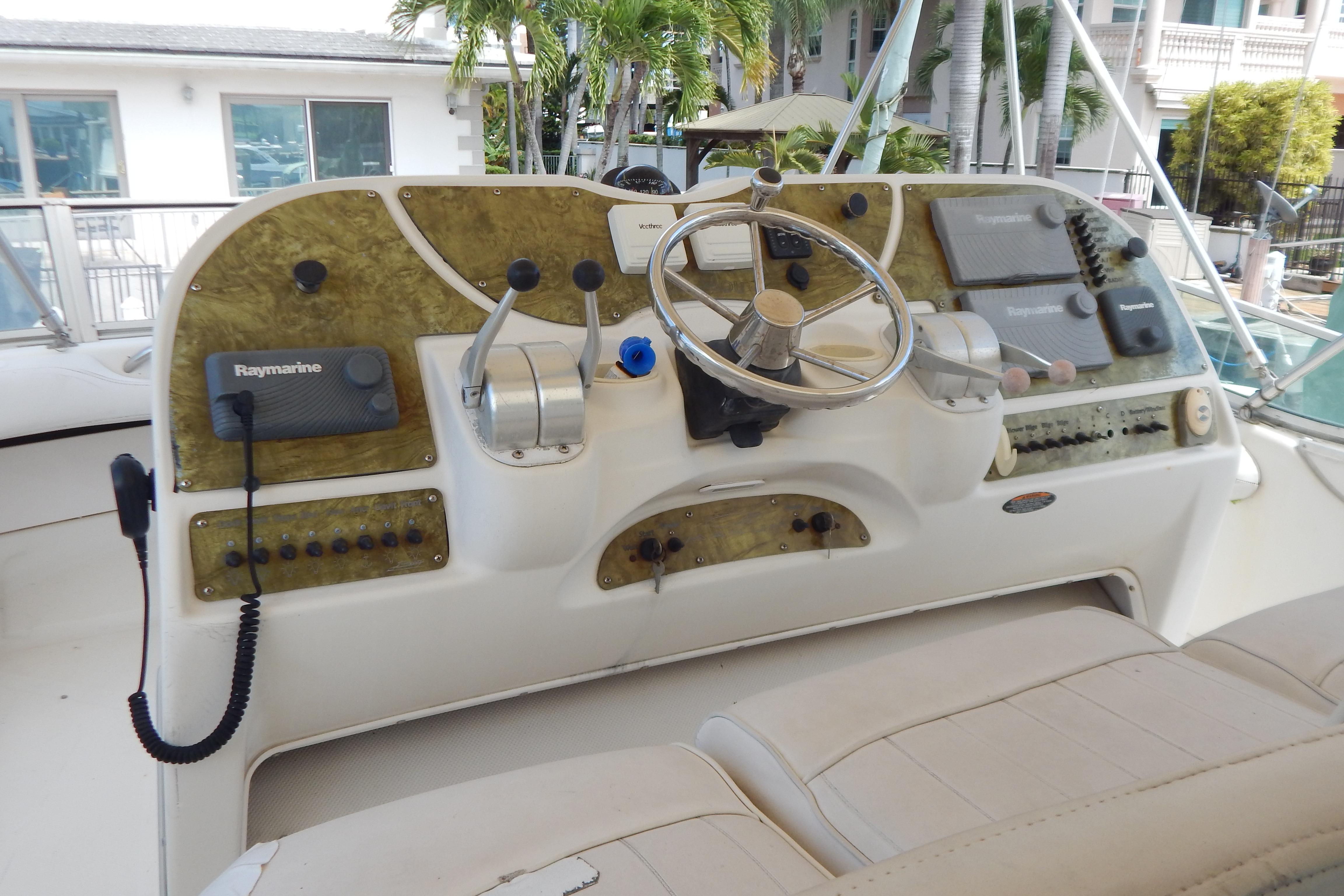 Control panel of a 1998 Magnum 4100 SCR boat with steering wheel and navigation equipment.