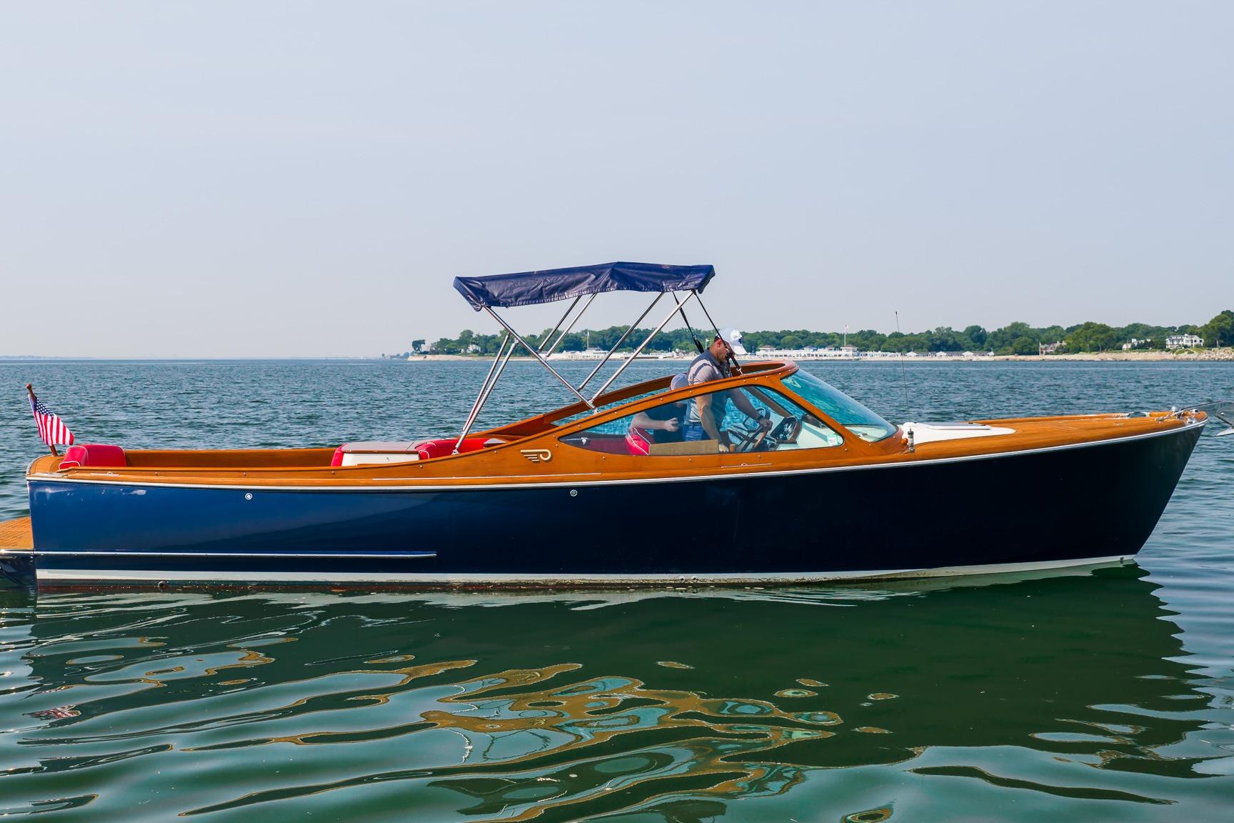 2005 Hinckley Talaria 29R boat cruising on calm waters with scenic shoreline.