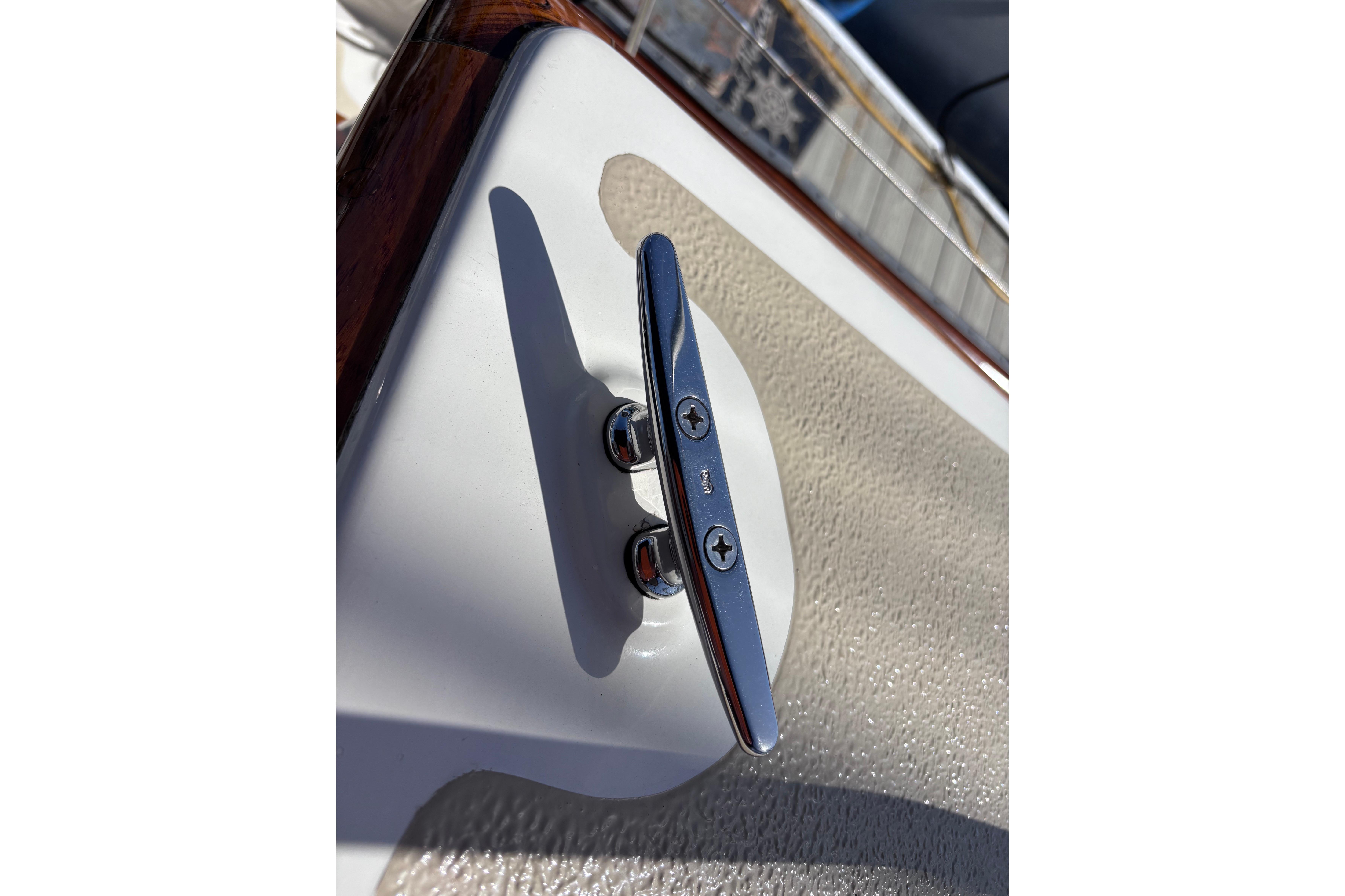 Chrome boat cleat on a 1978 Swift 33, mounted on textured surface.