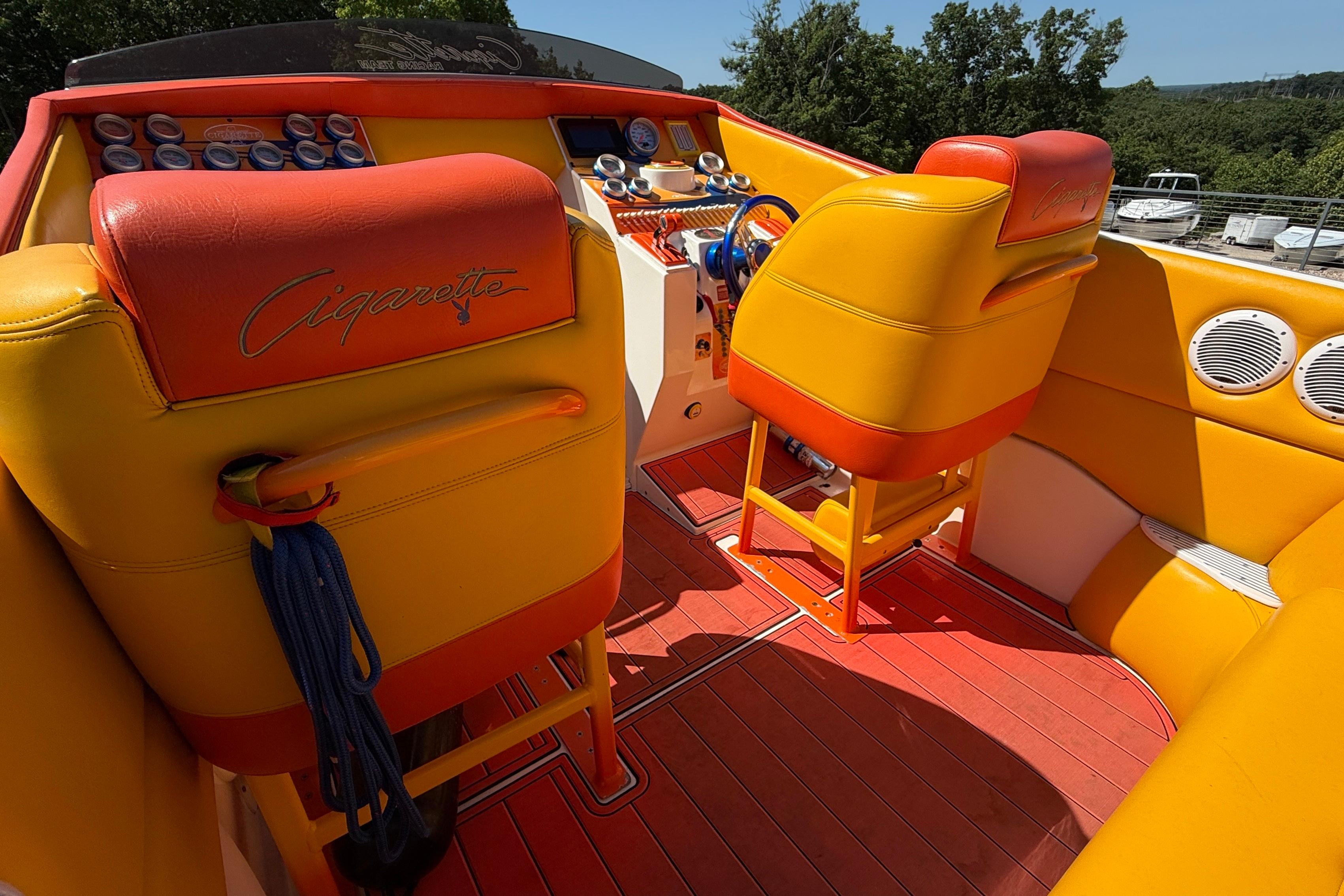 Interior of a 2002 Cigarette 35' Cafe Racer boat with vibrant orange and yellow seating.