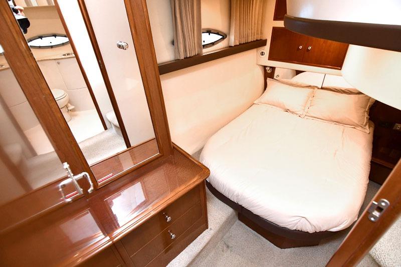 Luxurious bedroom interior of 2008 Carver 43 Super Sport yacht with cozy bed and elegant wood finish.