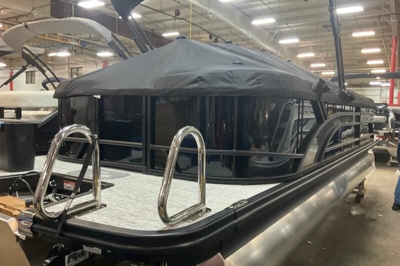 2026 Bennington 23 SSRSF pontoon boat with black canopy in a showroom.