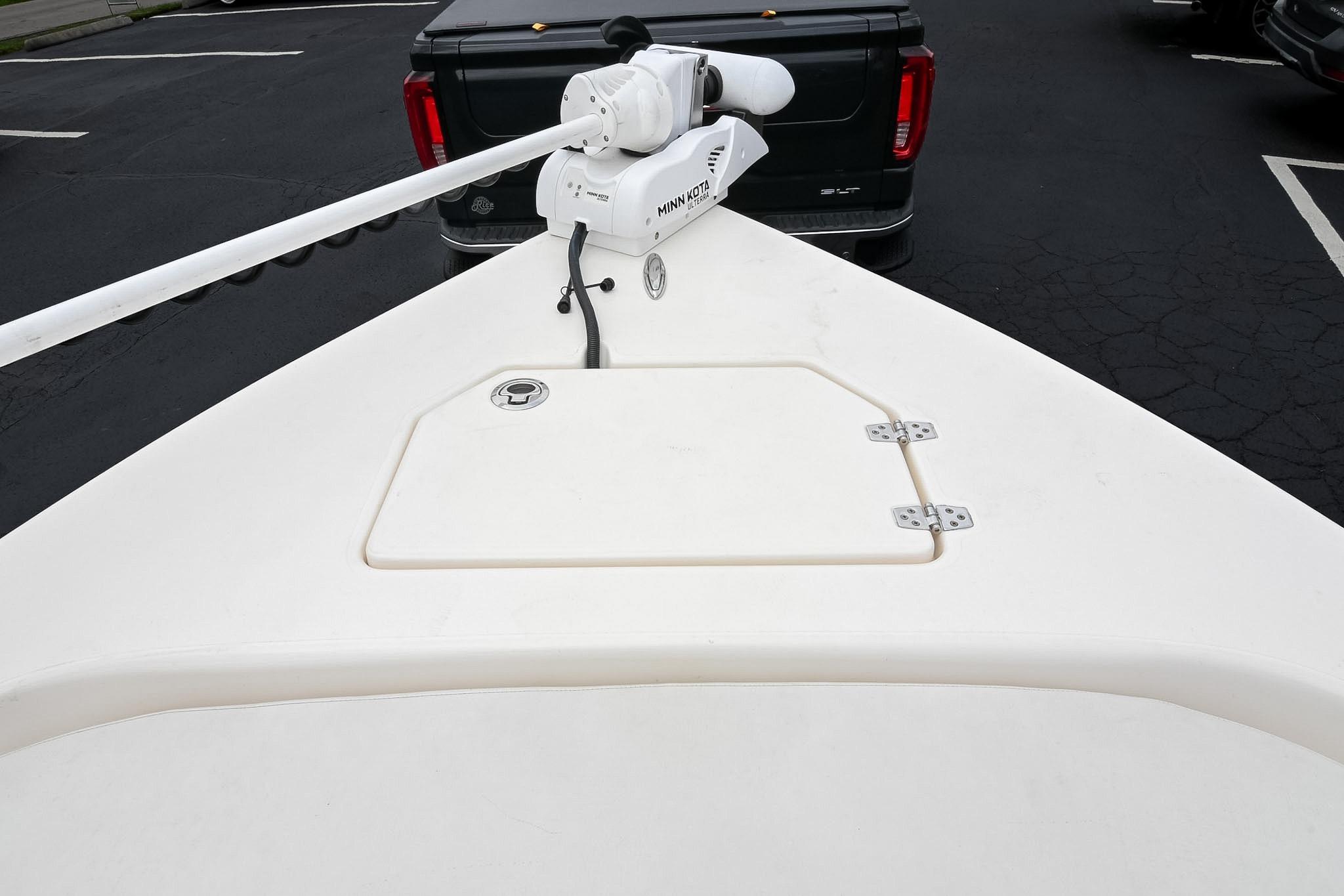 Bow of 2021 Pathfinder 2200 TRS boat with trolling motor in parking lot.