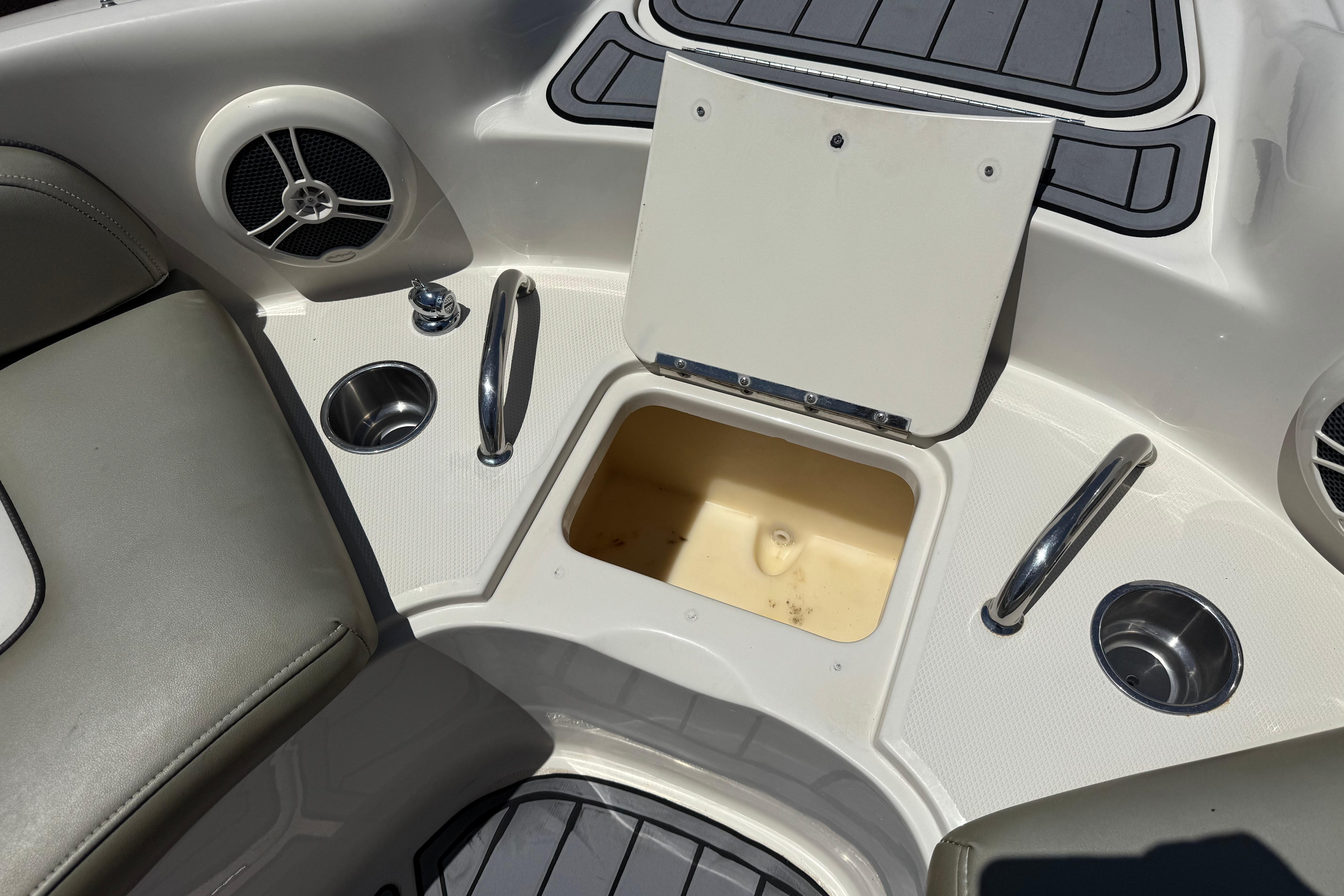 Interior of a 2007 Sea Ray 240 Sundeck boat with storage compartment and cup holders.