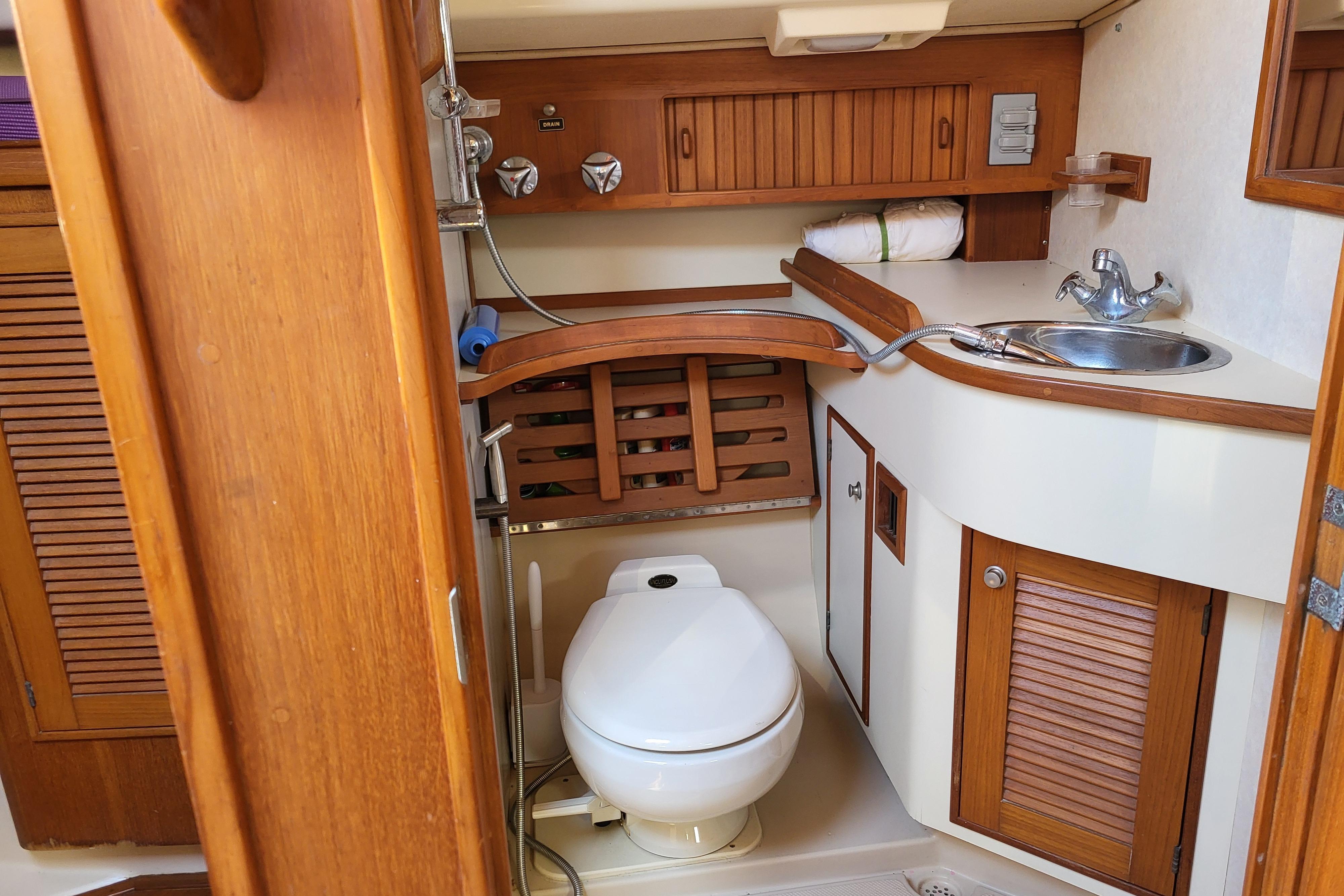 Interior of 2000 Island Packet 420 yacht bathroom with wooden cabinetry and compact design.