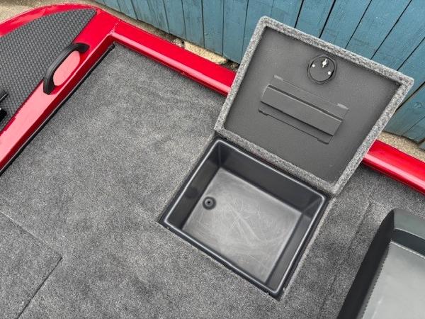 Open storage compartment on 2025 Tracker Savage 215 boat with gray carpeted deck.