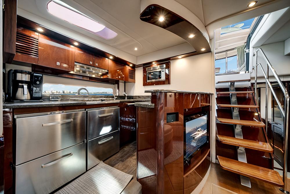 Luxurious 2012 Sea Ray 610 Sundancer yacht interior with modern kitchen and elegant wooden staircase.