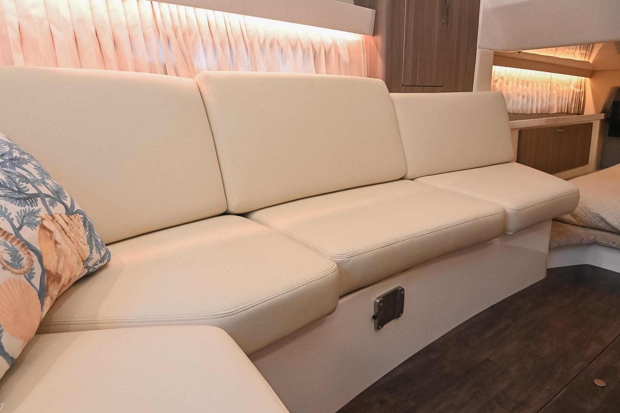 Interior of 2021 Regal 33 Express yacht with beige seating and decorative pillow.