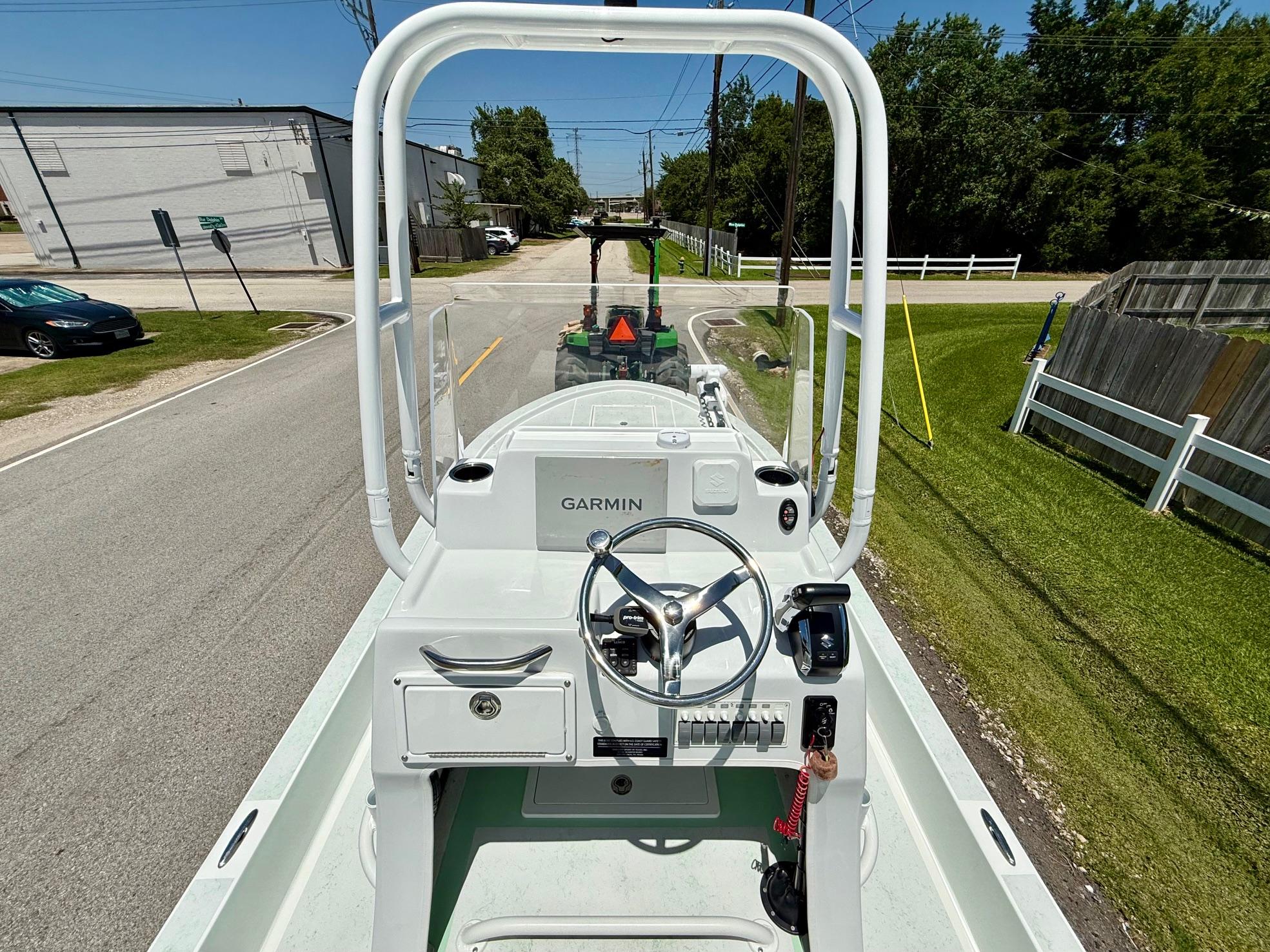 2023 Shallow Sport 24 Sport boat on road, featuring Garmin navigation system.