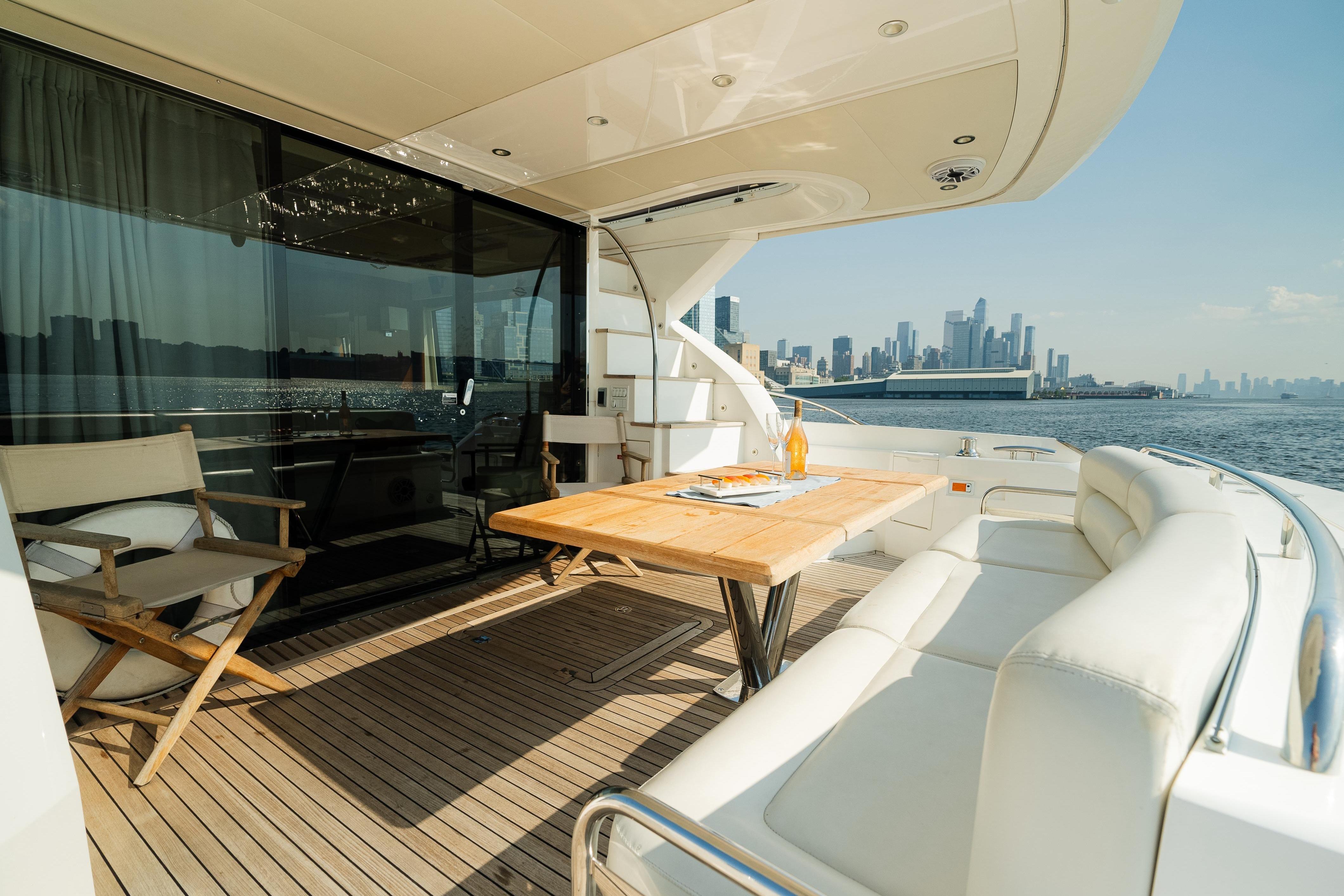 Luxurious 2016 Sunseeker Manhattan 65 yacht deck with city skyline view.