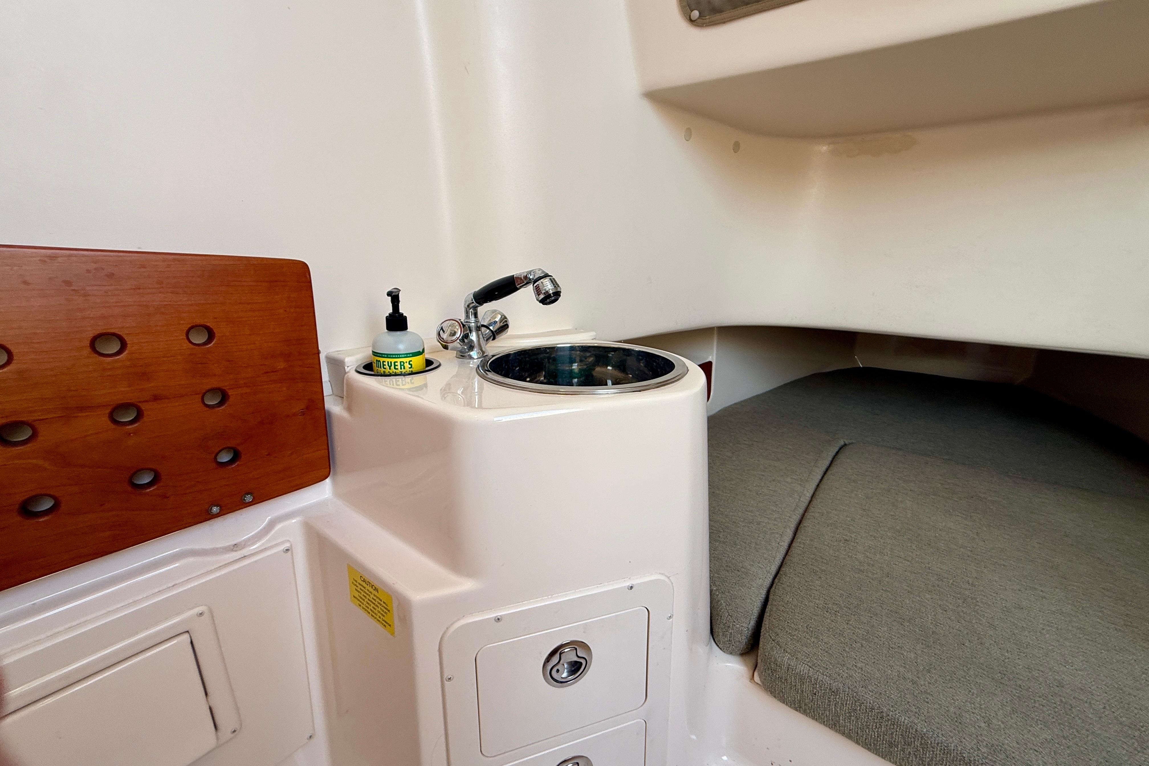 2012 Grady-White Canyon 336 cabin interior with sink and cushioned seating area.